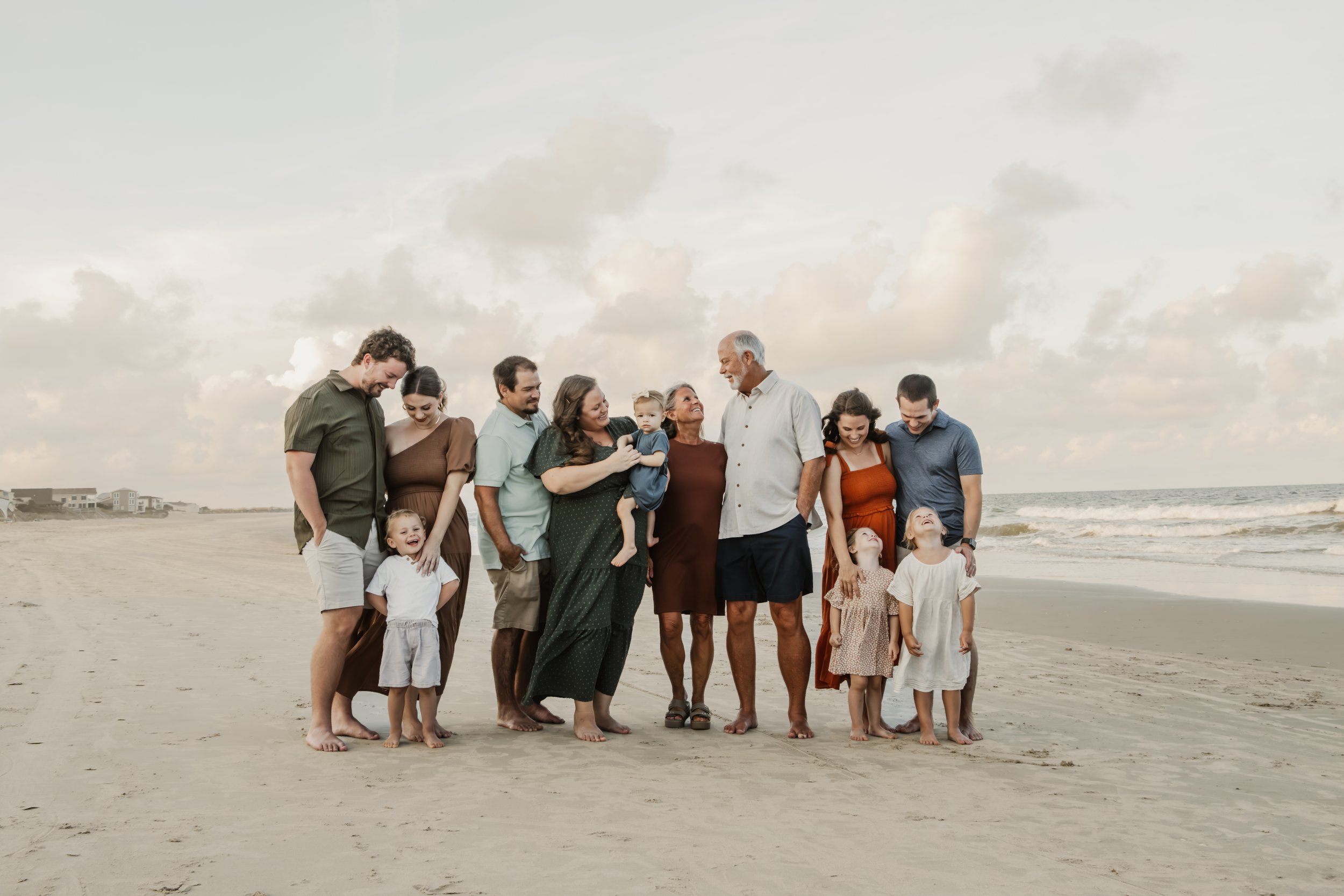 Family with children walking on the beach, smiling and enjoying the moment.