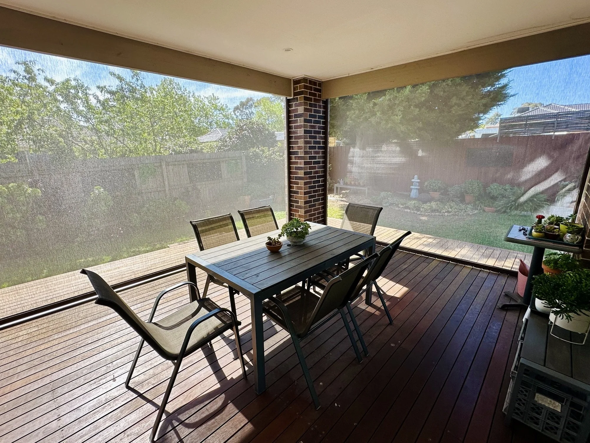 Outdoor ZIP blinds enclosing a covered alfresco dining area with timber decking
