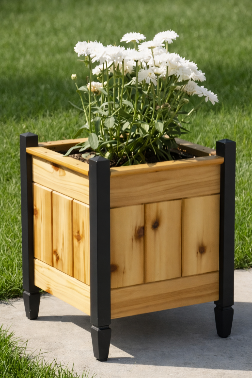 Empire Series cedar planter box with black wood legs, handcrafted outdoor wooden planter for flowers and garden décor, shown on a patio with white blooms.