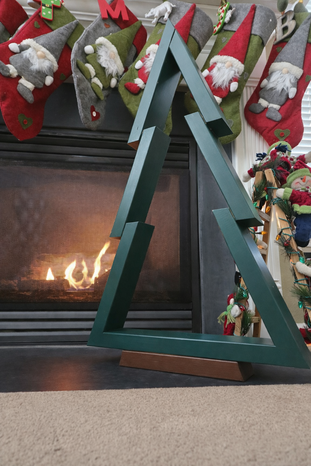 Star-shaped fireplace mantel with Christmas stockings hanging above, decorated with small gnome figures and holiday ornaments.
