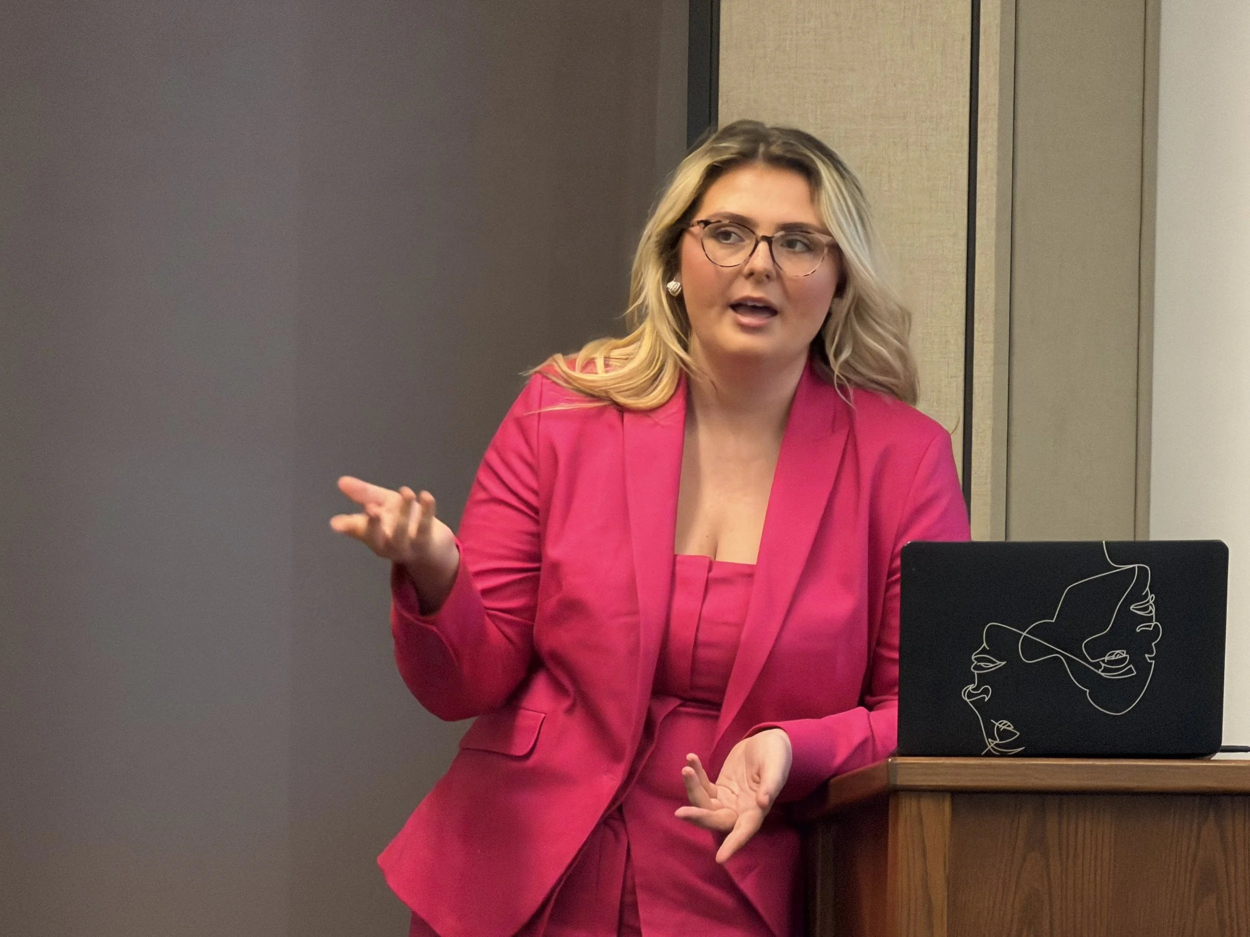 woman in pink suit talking
