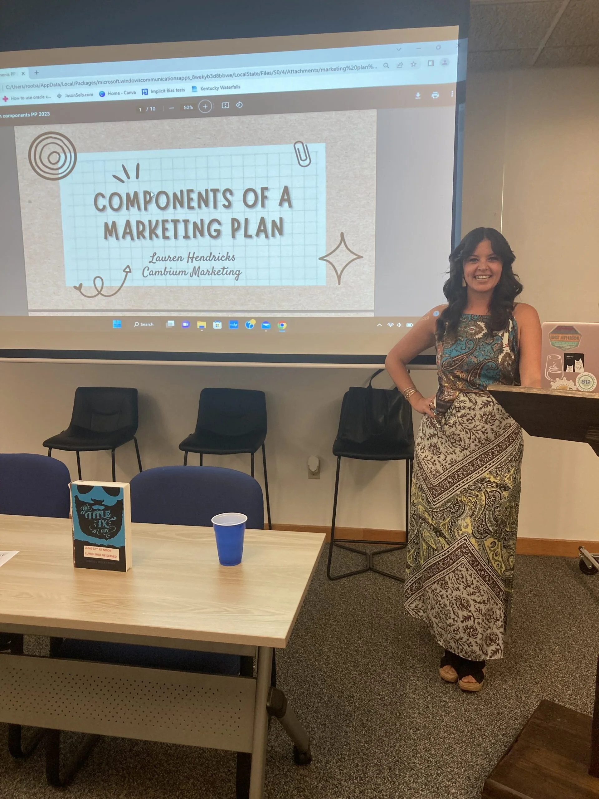 Woman posing with presentation on screen