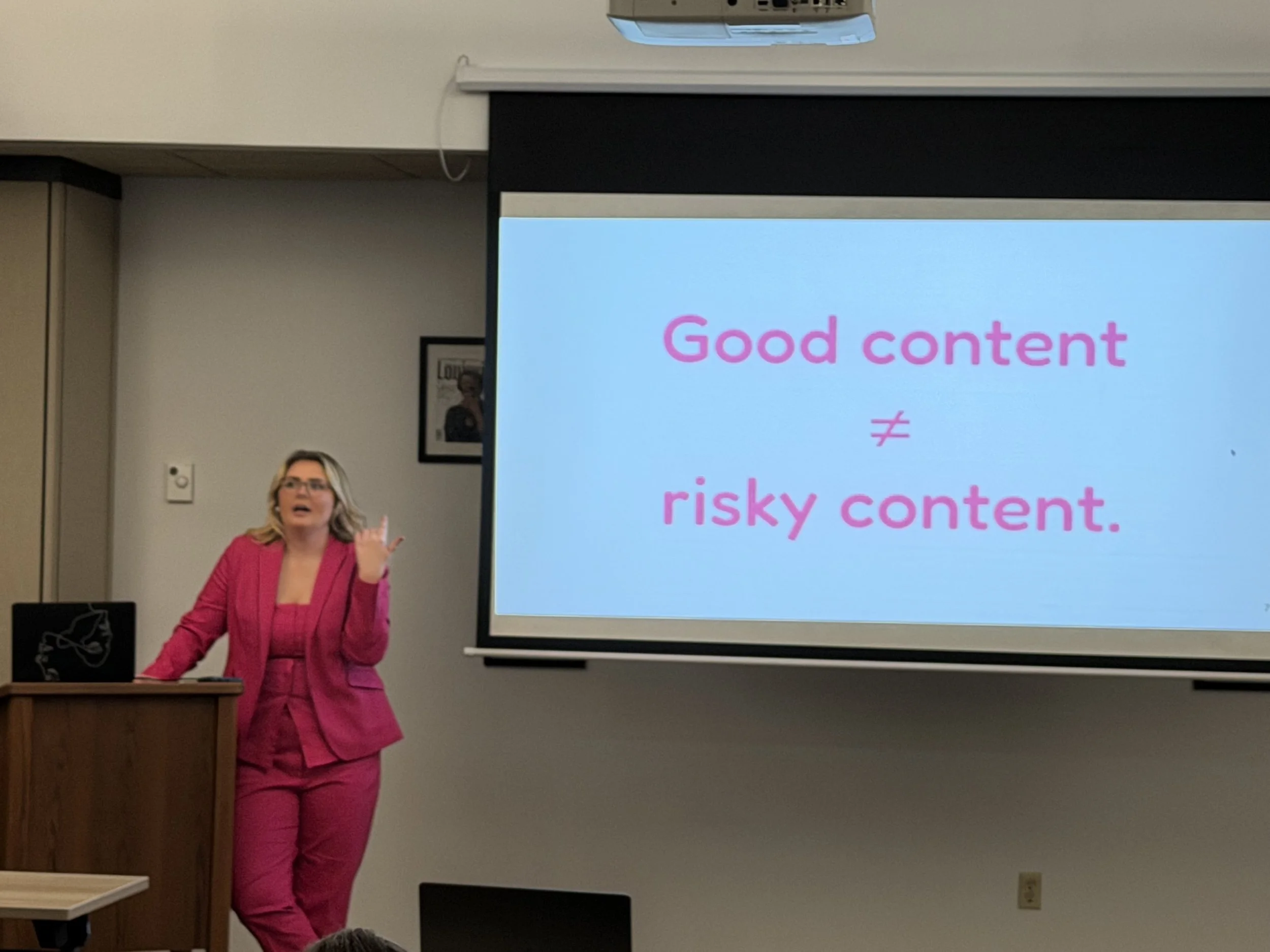 woman in pink suit presenting on screen