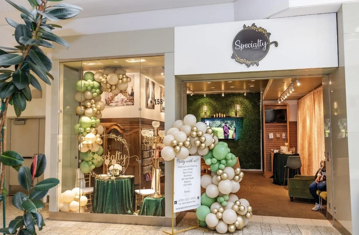 The storefront for Sportify, a business with floral decorations, green and gold balloons, and interior decor visible through glass doors.