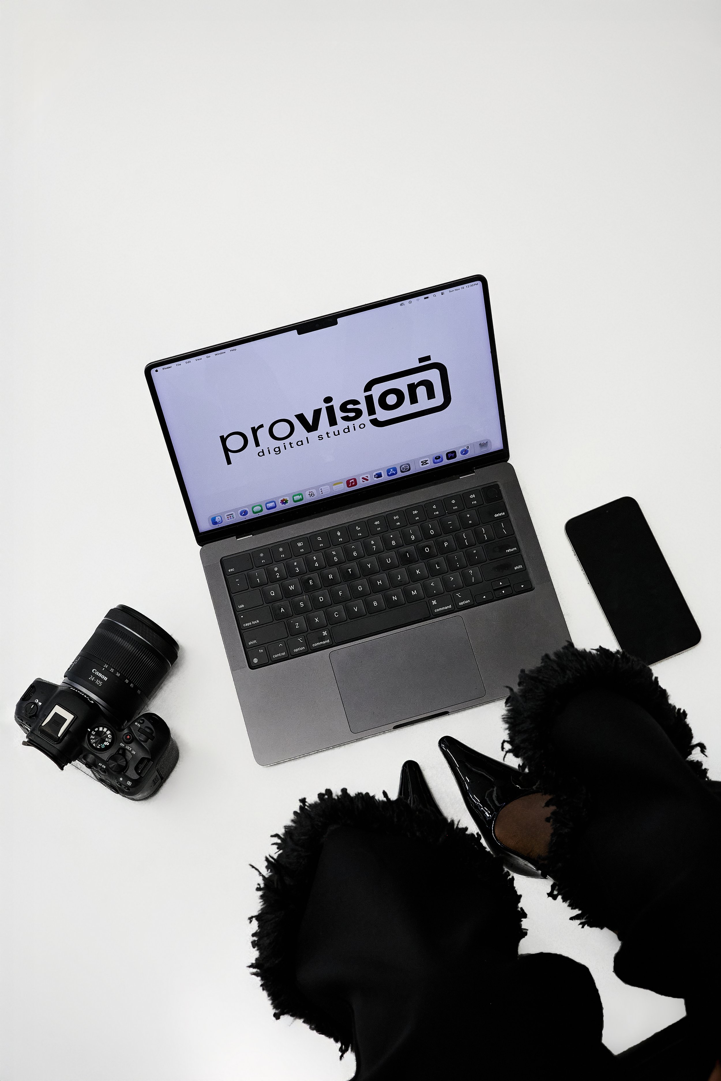 Overhead shot of computer with Provision Digital Studio logo and camera and phone surrounding the computer.