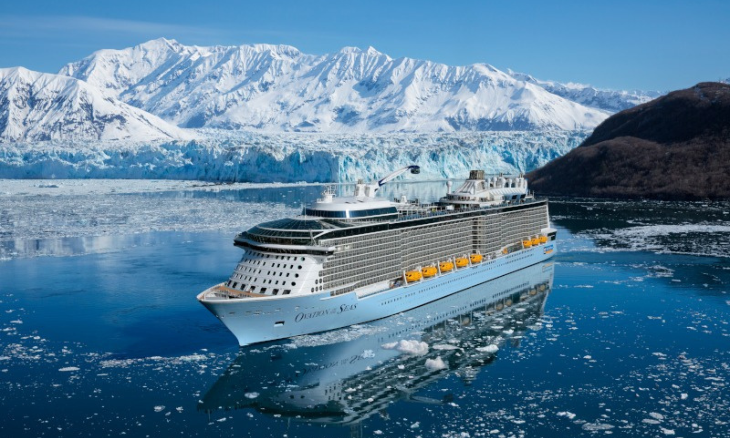 Luxury Alaska cruise ship sailing past glaciers and mountains planned by a travel agent