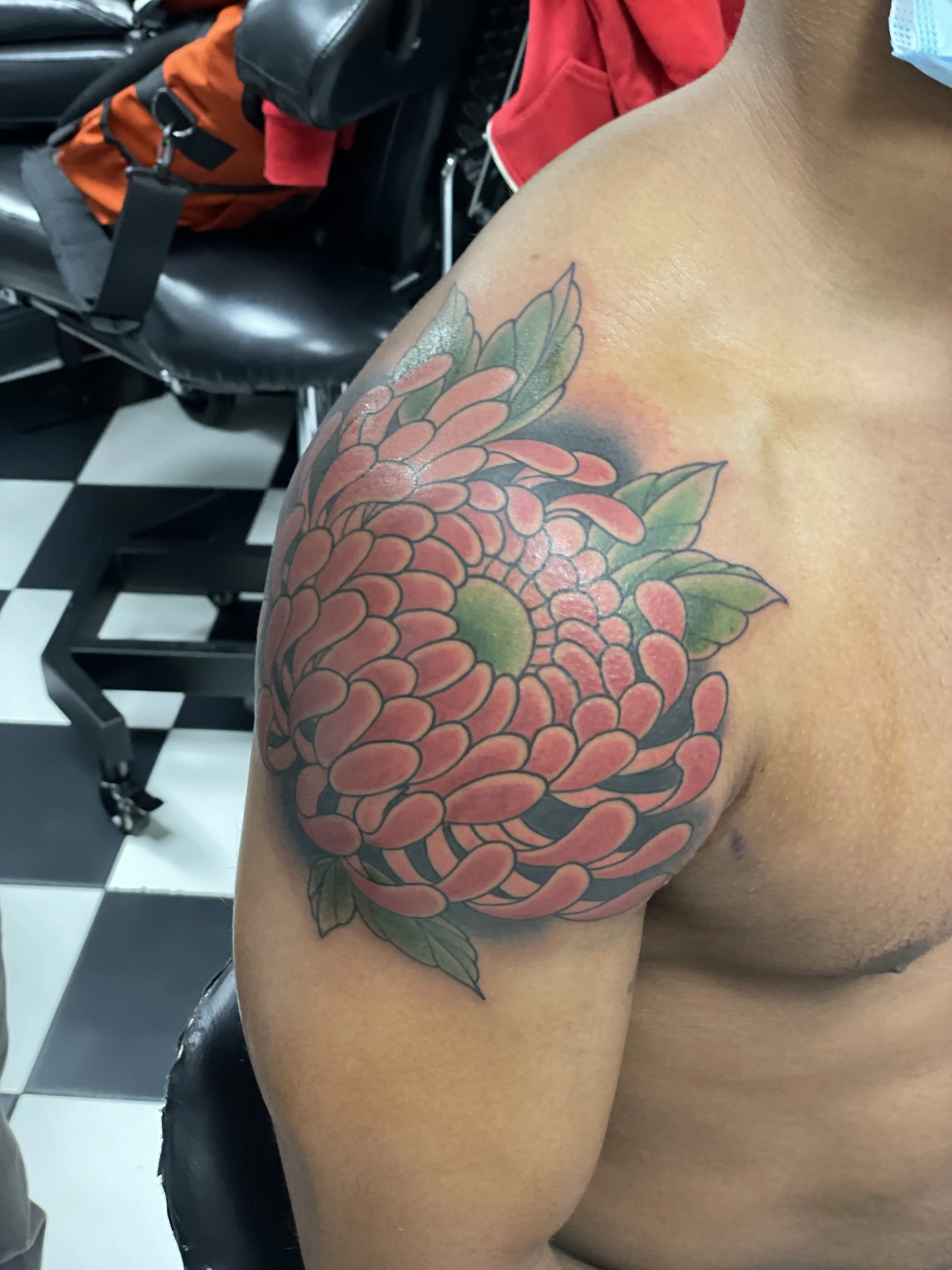Layer after layer of tightly packed pink petals spreading across the shoulder and onto the chest. This chrysanthemum is executed beautifully. Japanese color shoulder tattoo by Nick at Big Kahuna Tattoo in Boca Raton, FL.