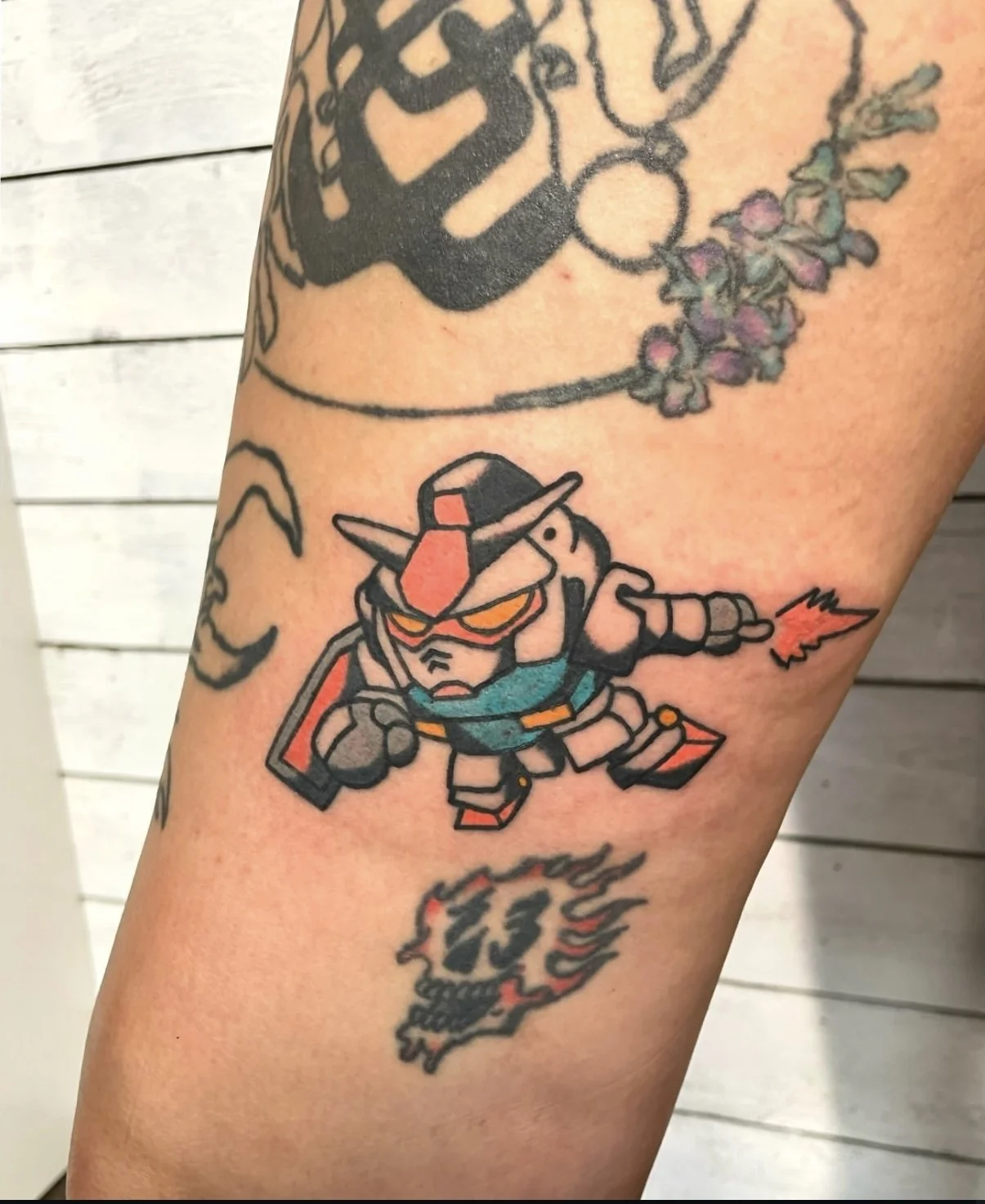 Color traditional forearm tattoo featuring a chibi style Gundam robot in fighting stance with orange energy, custom anime tattoo by Brandon Perez at Big Kahuna Tattoo in Boca Raton, FL