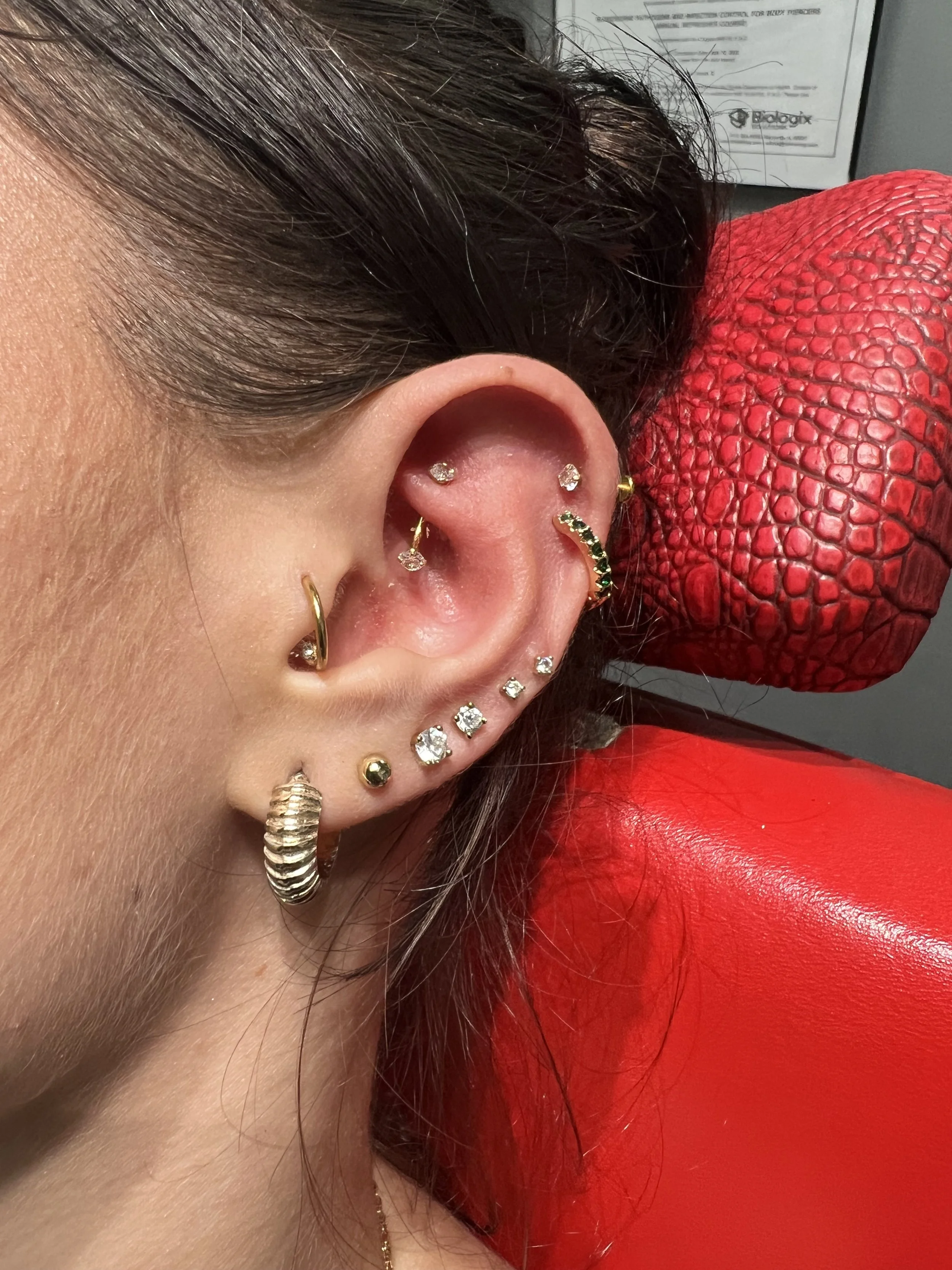 Professional ear piercing with gold hoops and diamond studs at Big Kahuna Tattoo in Boca Raton