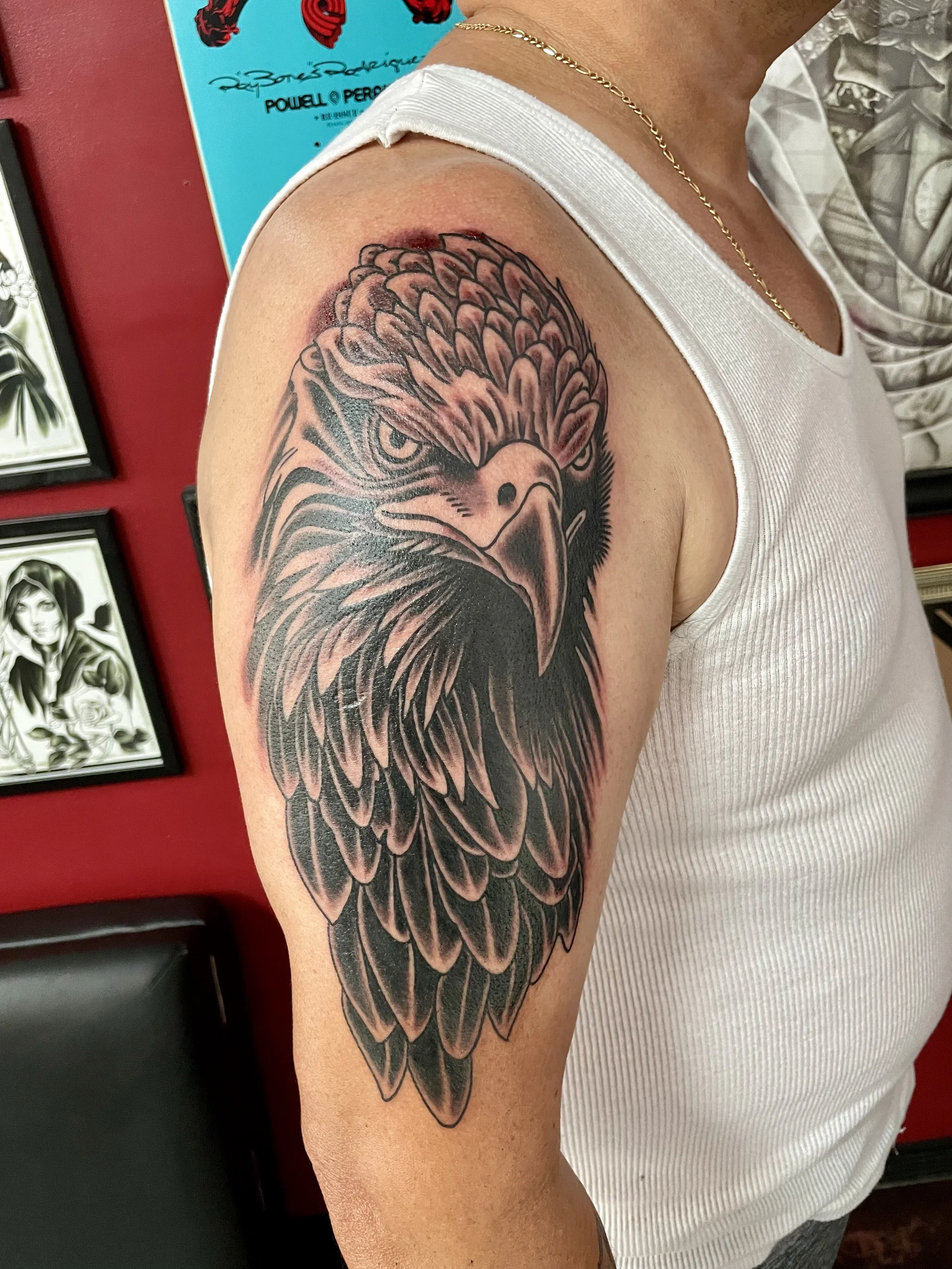 There's nothing subtle about a bald eagle staring you down from the upper arm. Sharp feathering, a hooked beak, and a piercing expression. This is the kind of tattoo that commands a second look. Black and grey upper arm tattoo by Nick at Big Kahuna T