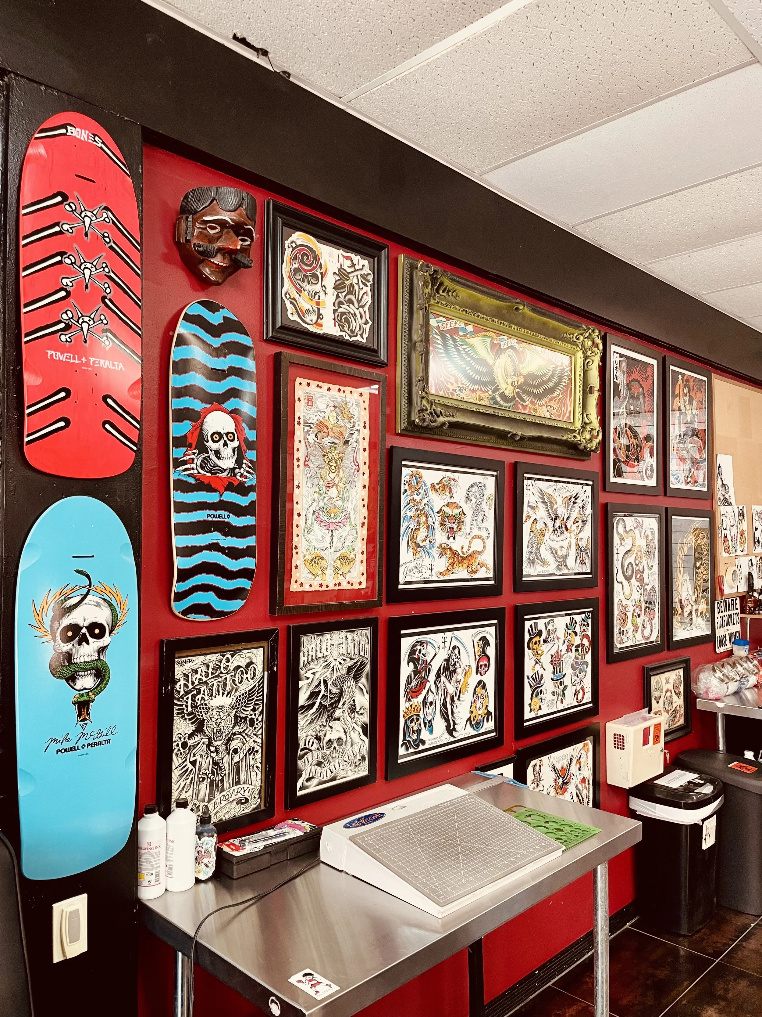 Tattoo artist station and flash art wall at Big Kahuna Tattoo in Mizner Park, Boca Raton