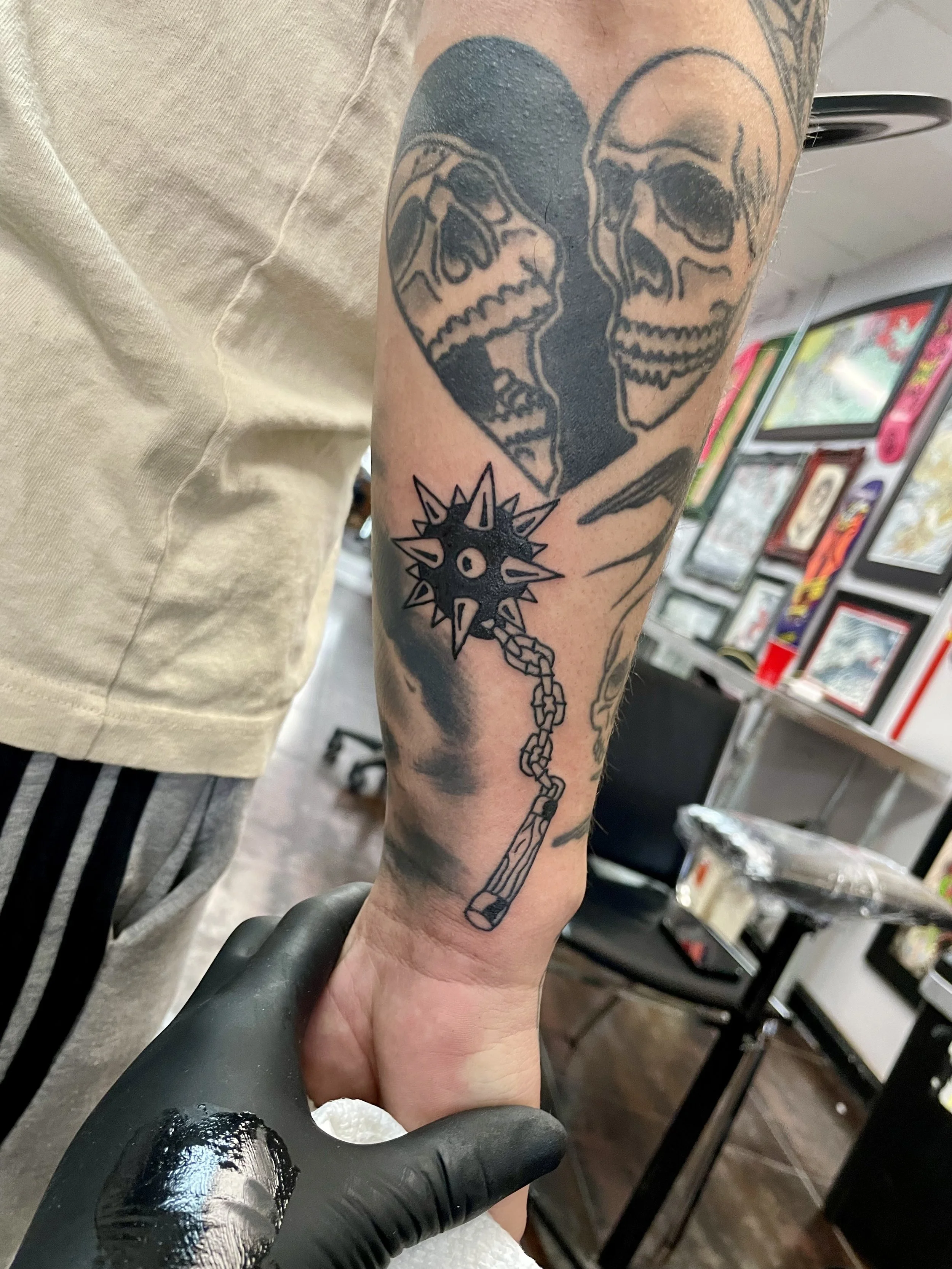 Black and grey forearm tattoo a spiked flail on a heavy chain, custom tattoo by Nick at Big Kahuna Tattoo in Boca Raton, FL.