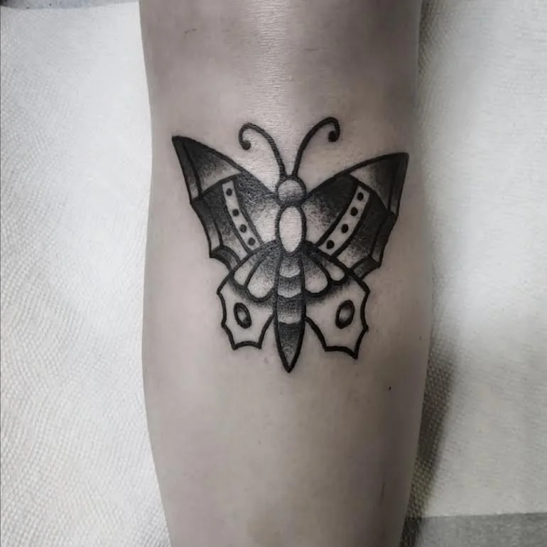 Black and grey traditional butterfly tattoo with bold linework and decorative wing detailing on the leg, custom tattoo by Brandon Perez at Big Kahuna Tattoo in Boca Raton, FL
