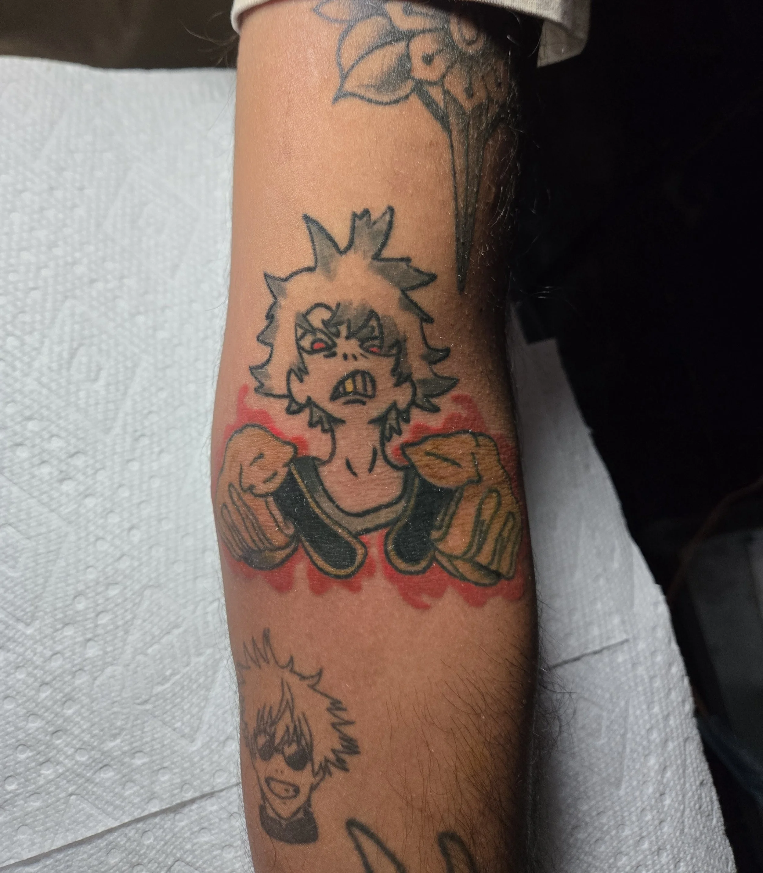 Color traditional forearm tattoo featuring Rudo from the manga Gachiakuta with red eyes and raised fists surrounded by red energy, custom anime tattoo by Brandon Perez at Big Kahuna Tattoo in Boca Raton, FL