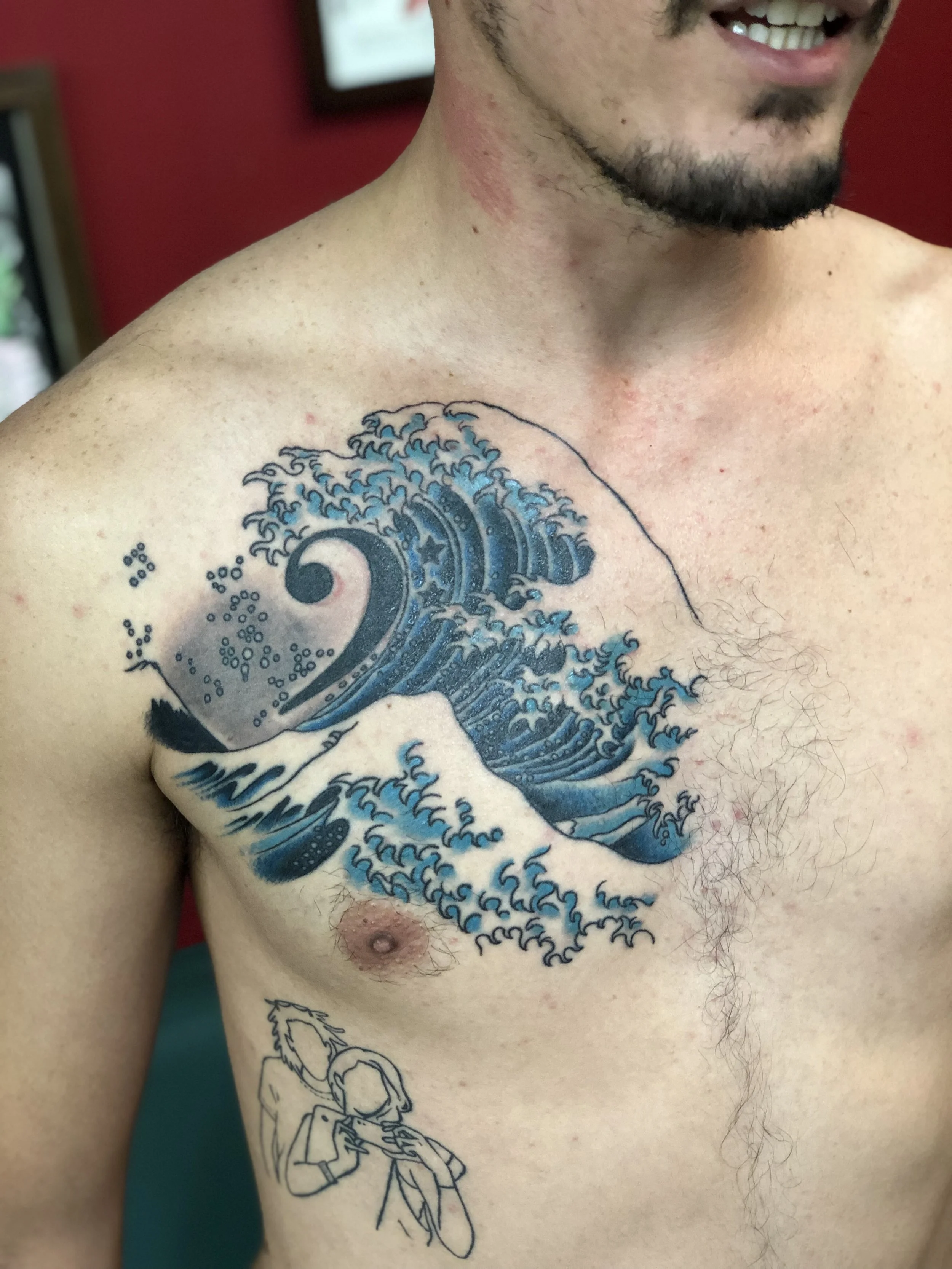 Japanese style color chest tattoo inspired by Hokusai's Great Wave, featuring bold blue ocean waves with detailed foam and whitecaps, custom tattoo by Nick at Big Kahuna Tattoo in Boca Raton, FL.