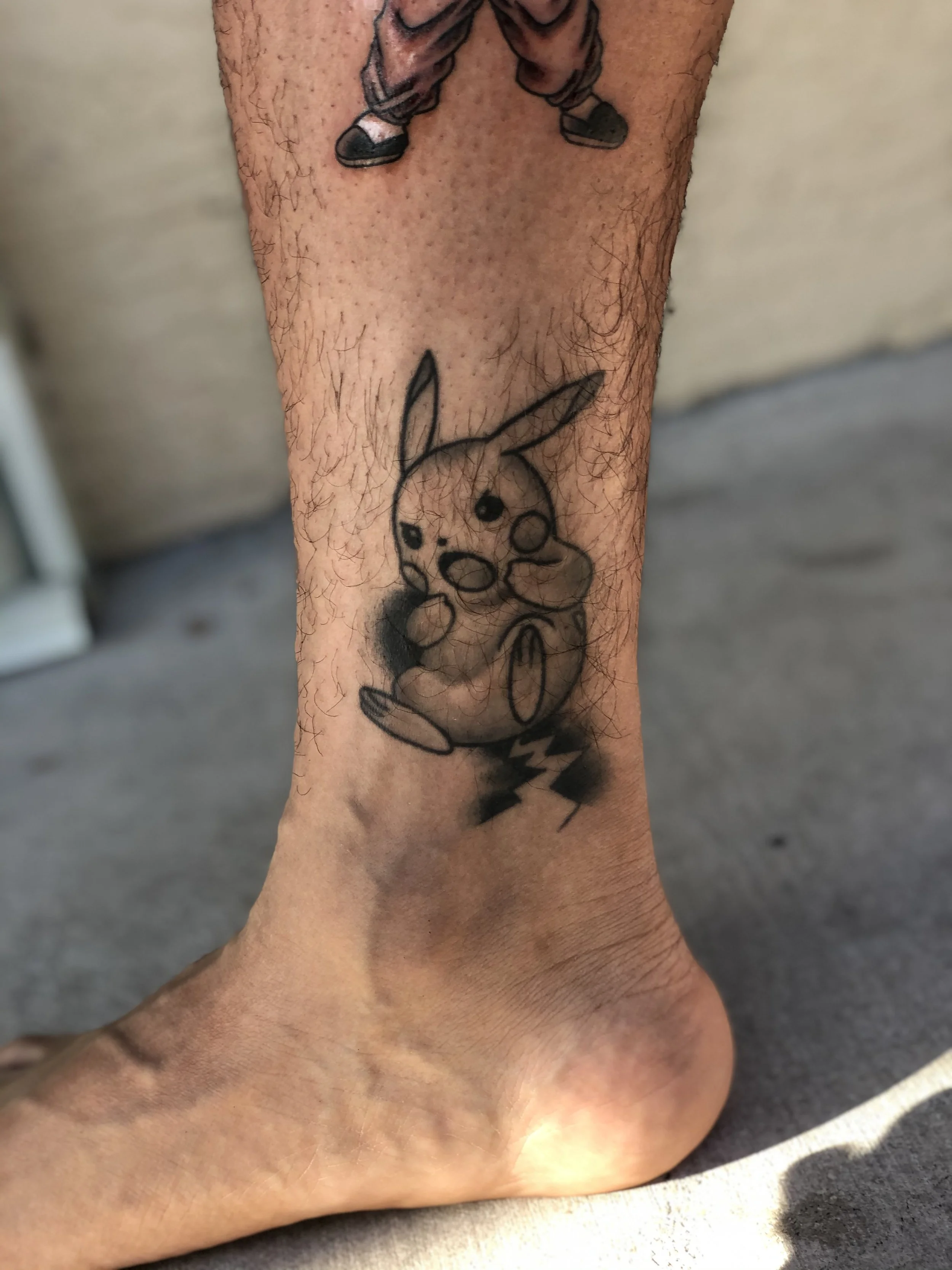 Minimalist black and grey ankle tattoo featuring Pikachu from Pokemon in a loose sketchy style with a lightning bolt, custom tattoo by Nick at Big Kahuna Tattoo in Boca Raton, FL.