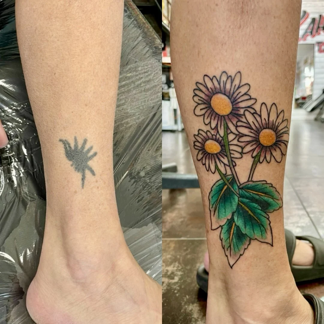 Before and after cover-up tattoo on the ankle, transforming a faded black scratch-style tattoo into a vibrant color bouquet of three daisies with golden yellow centers, white petals, and lush green leaves, custom cover-up tattoo by Nick at Big Kahuna