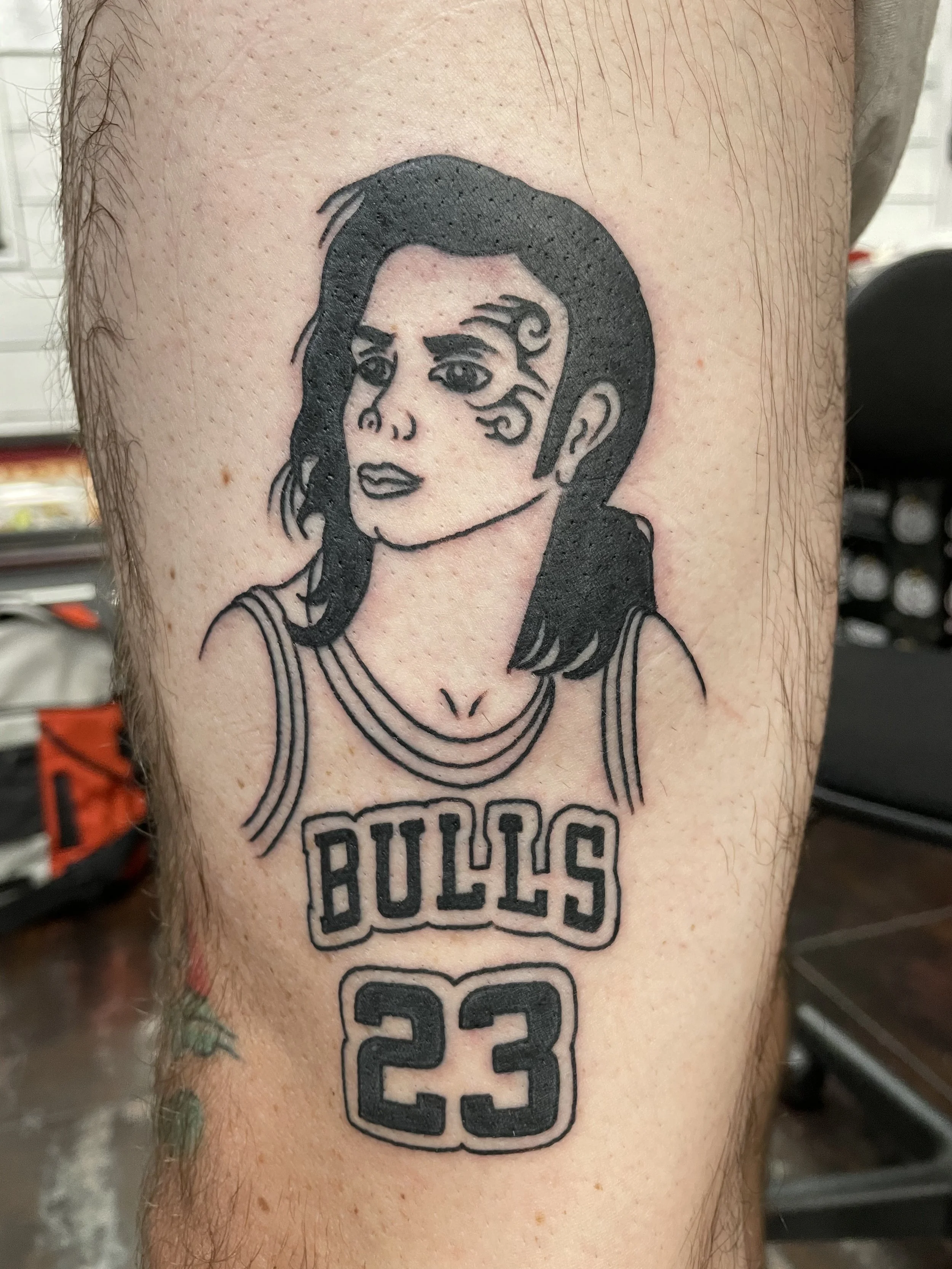 Black and grey leg tattoo featuring a bold illustrated portrait of the 3 Michael's - Michael Jackson wearing Michael Jordan's jersey, while having Mike Tyson's tribal tattooed on the side of his face, custom tattoo by Nick at Big Kahuna Tattoo in Boc