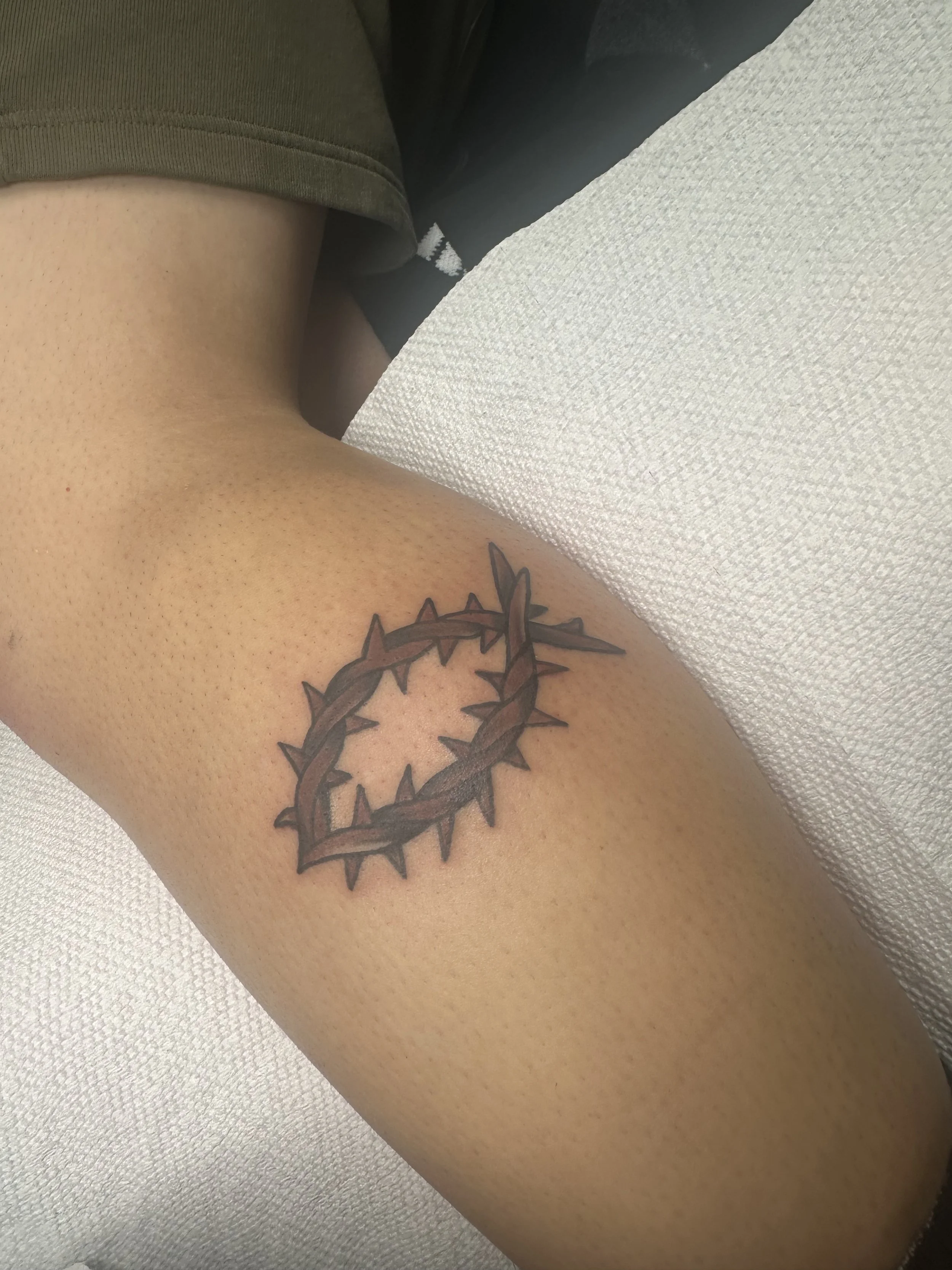 Black and grey upper arm tattoo featuring a bold crown of thorns in a Jesus fish shape with detailed linework and soft shading, custom tattoo by Dan at Big Kahuna Tattoo in Boca Raton, FL.