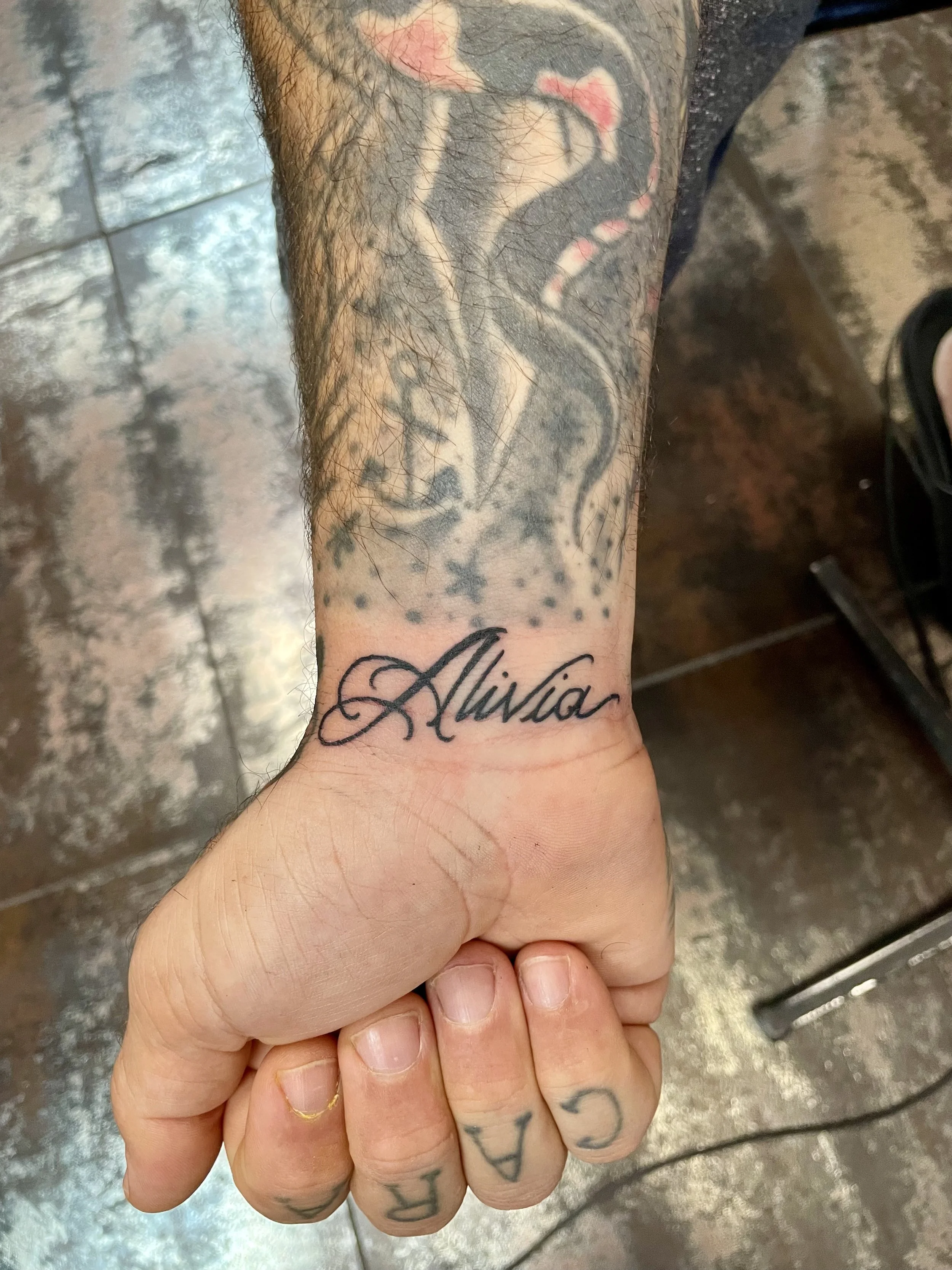 Bold script wrist tattoo featuring the name "Alivia" in elegant cursive lettering, custom tattoo by Nick at Big Kahuna Tattoo in Boca Raton, FL.