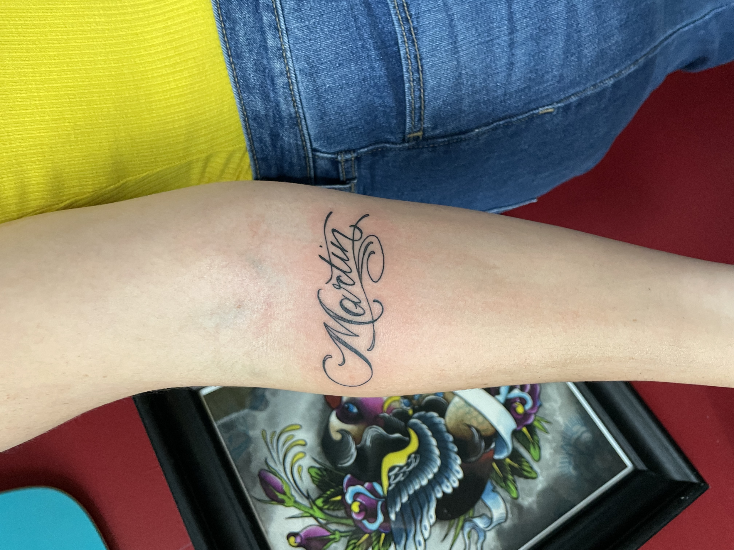 Fine line cursive script forearm tattoo featuring the name "Martin" in elegant ornate lettering, custom tattoo by Nick at Big Kahuna Tattoo in Boca Raton, FL.