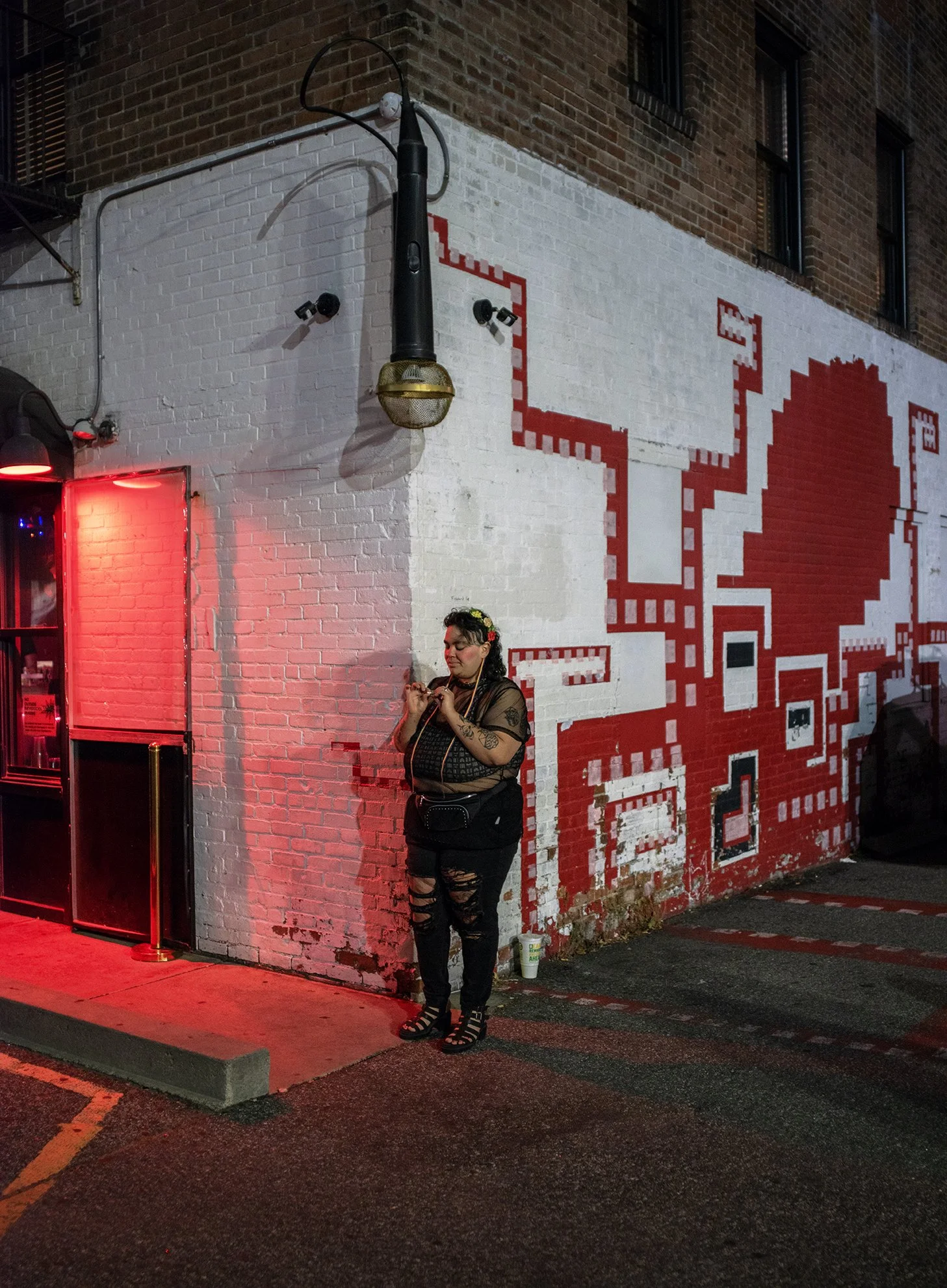 A person standing outside The Boombox Karaoke bar in Providence, RI.