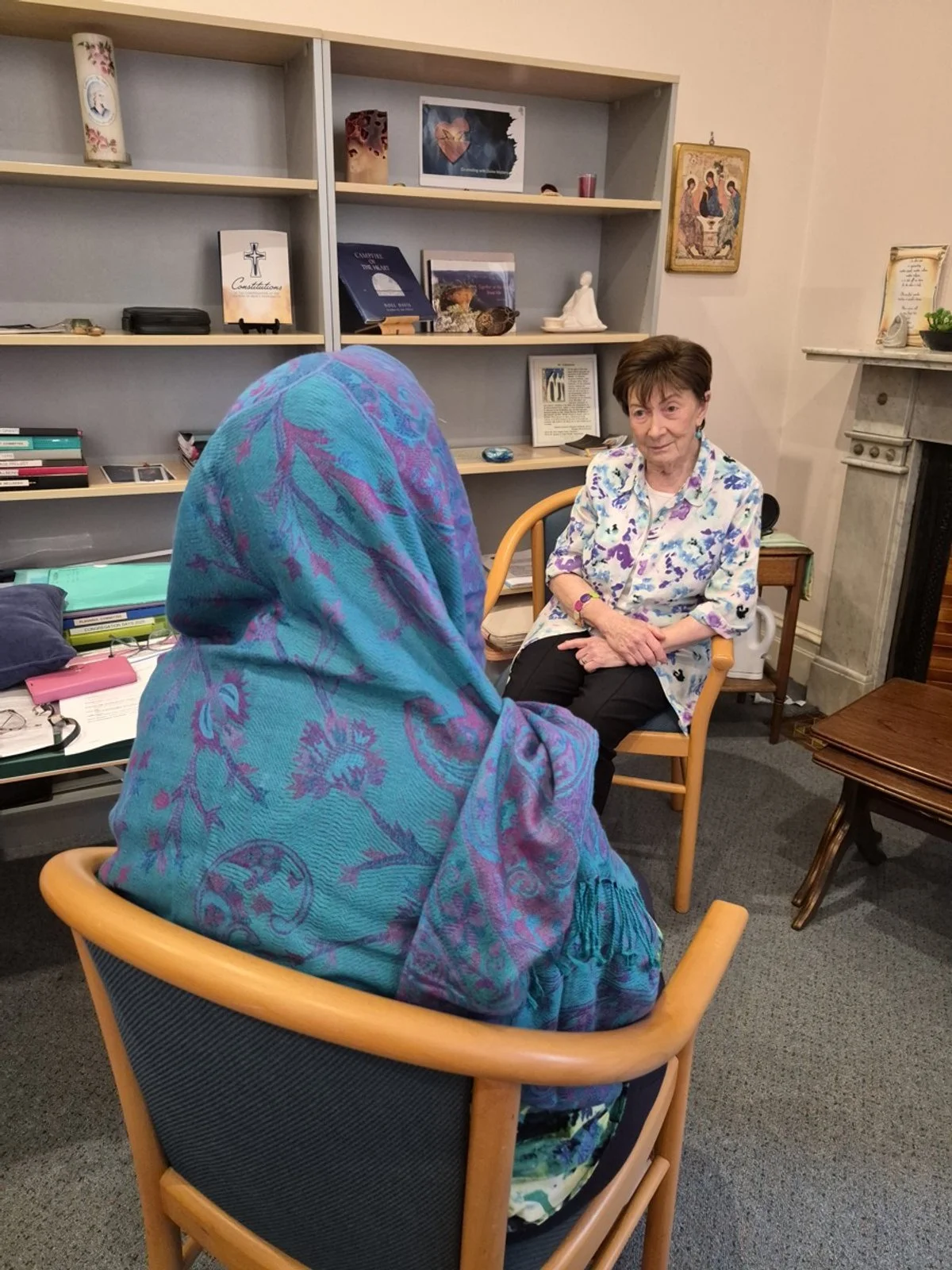 Sr Margaret rsm sitting with an asylum seeker.