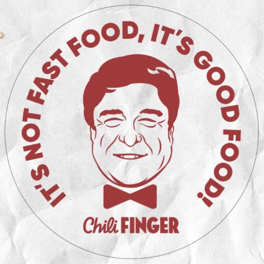 A circular logo with a stylized drawing of a smiling man with glasses and a bowtie. The text around the circle reads, "It's not fast food, it's good food!" and below, it says "Chili Finger." The logo has a white background and uses red for the text and illustration.