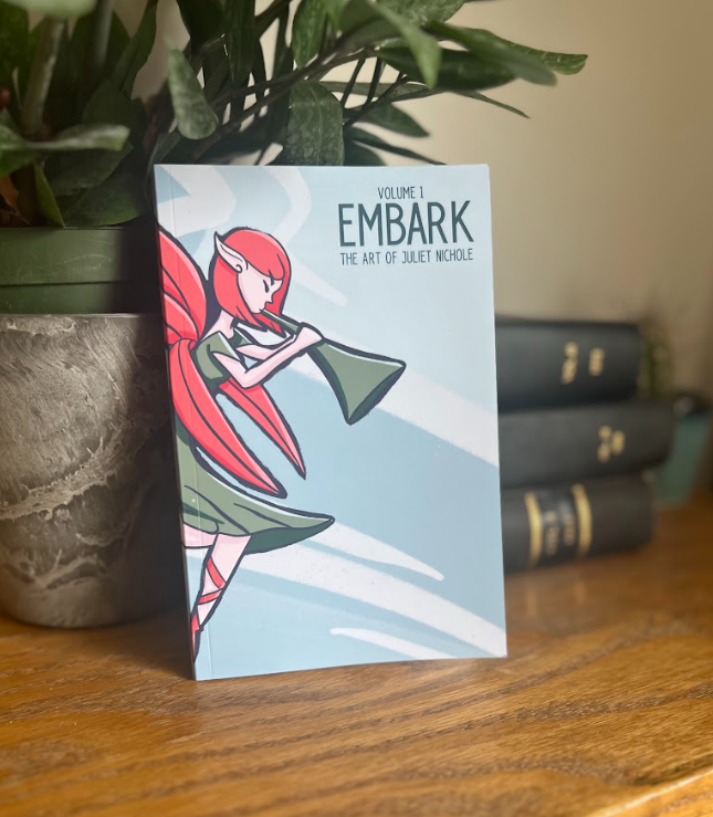 The author's art book: a blue book with a fairy dressed in green blowing on a trumpet