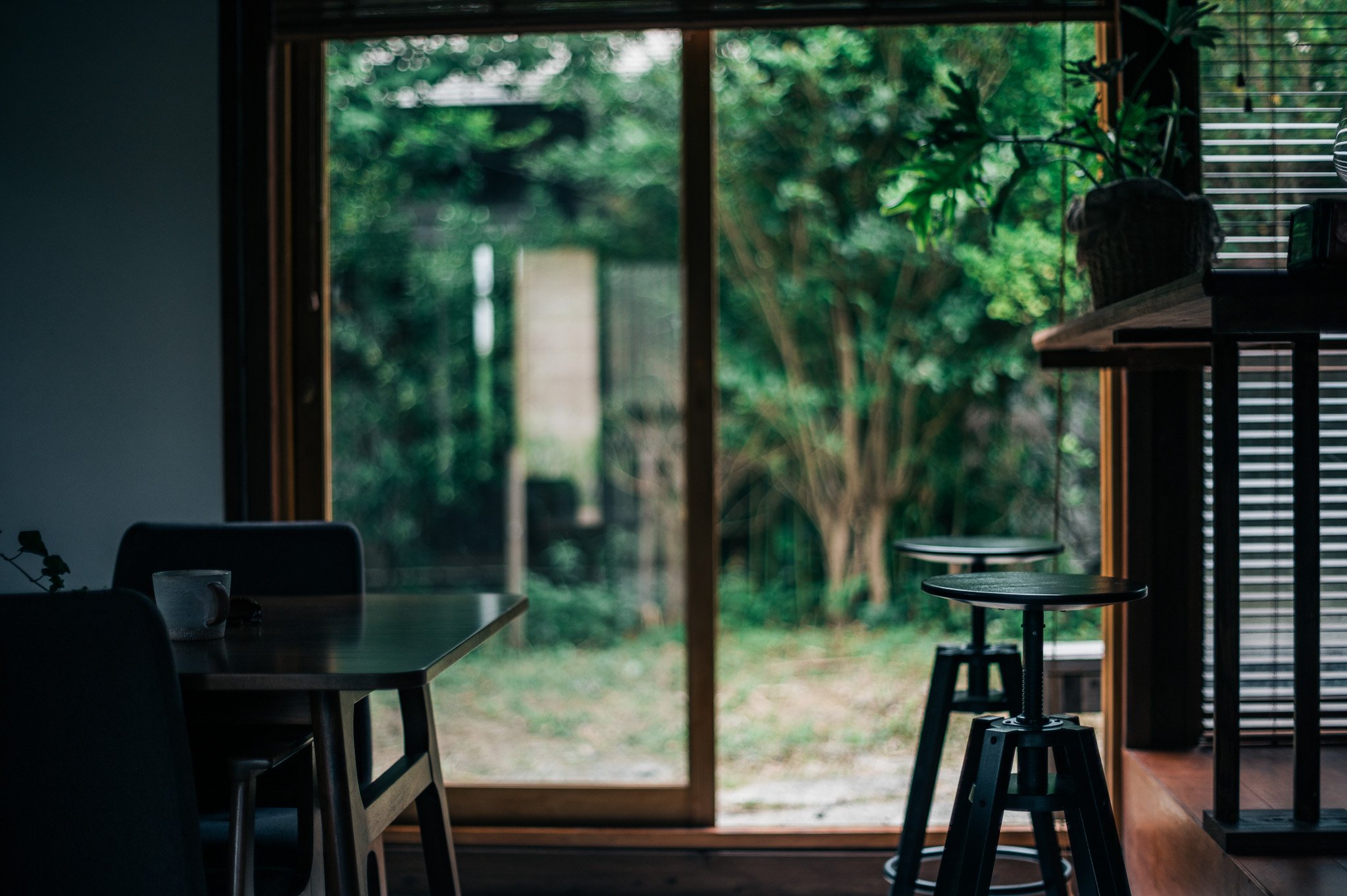 月見台住宅で小休思、が運営する民泊『月見台ハウス』の室内から見た緑豊かな庭