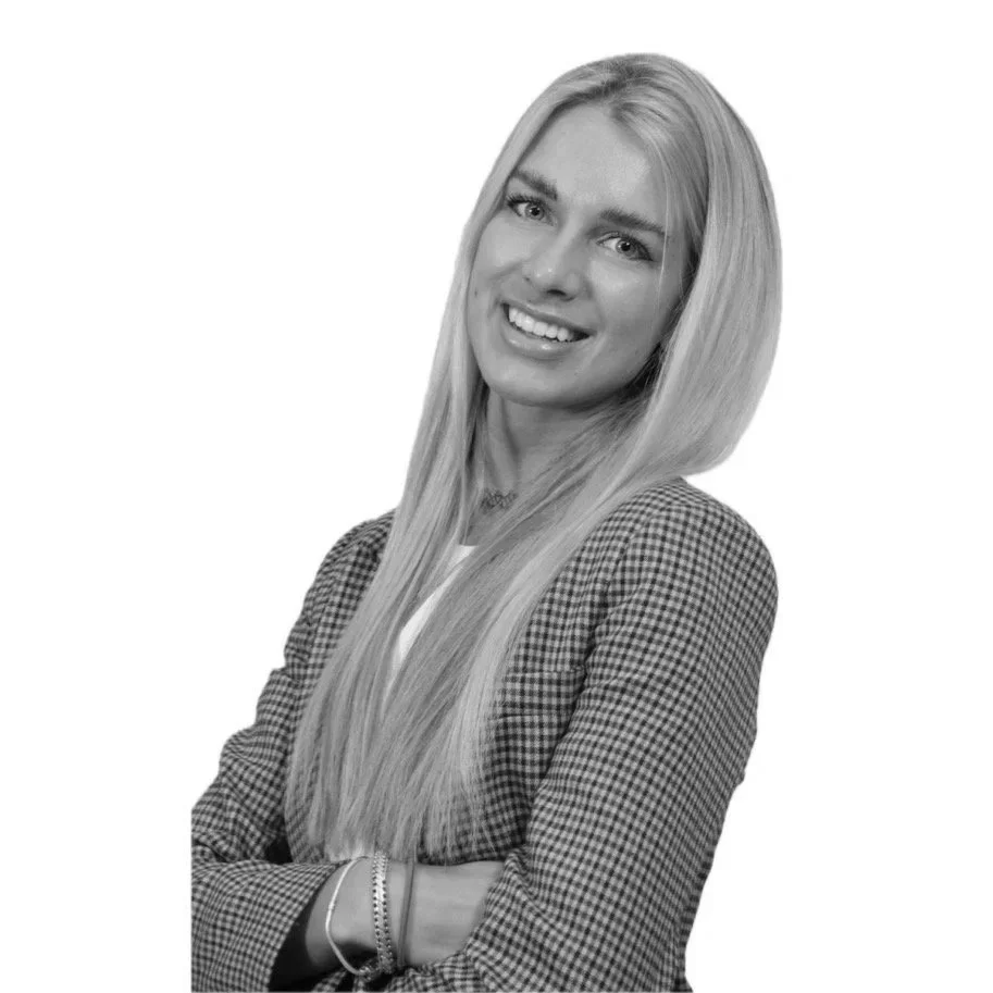 Zweedse vrouw met lang blond haar, glimlachend en gekleed in een geruite jas, foto in zwart-wit.