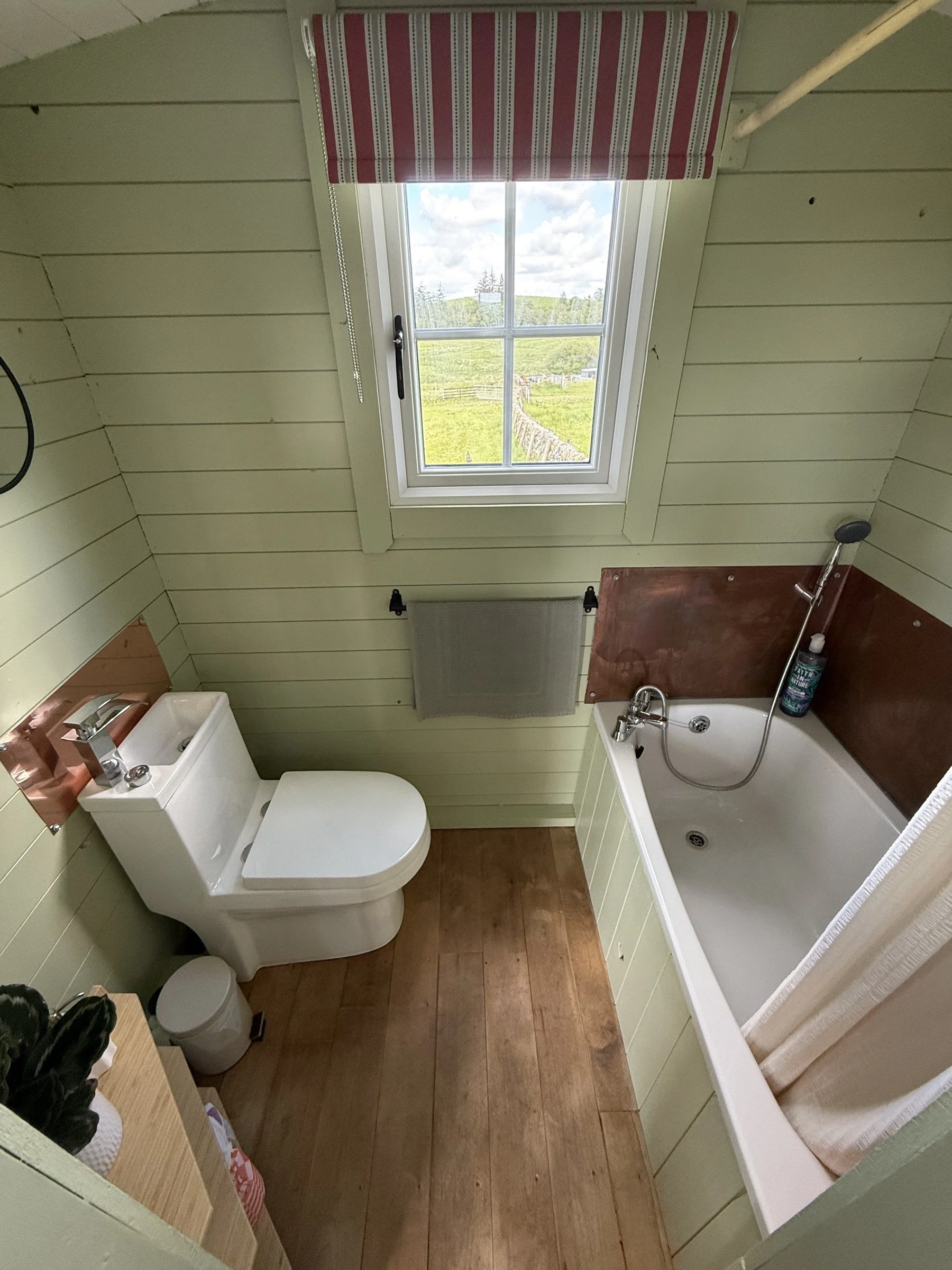 The ensuite bathroom, with a bathtub and shower head.