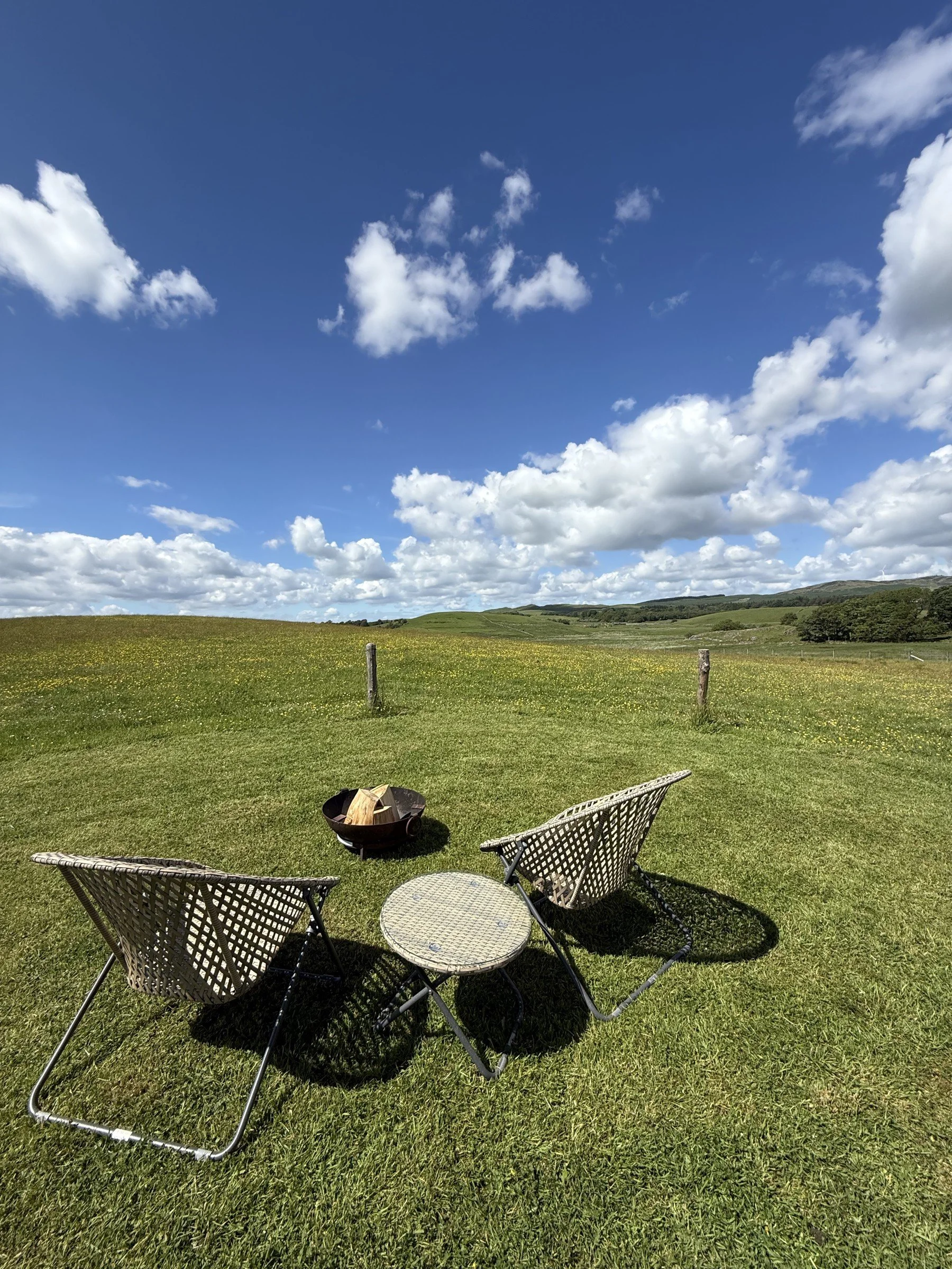 Outdoor chairs and a firepit with wide-open views.