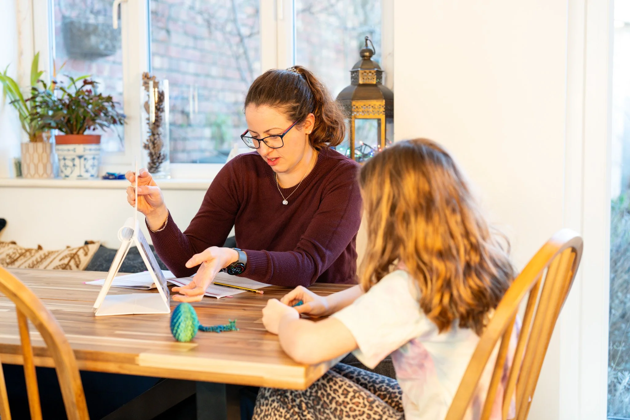 A woman and a child sit at a table looking at a small flip chart