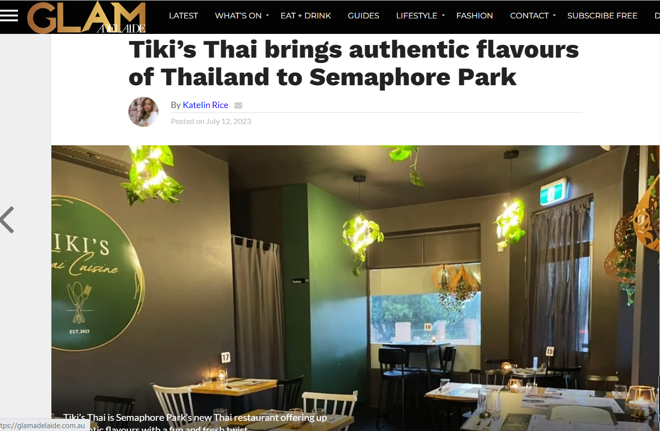 Interior of Tiki's Thai Cuisine restaurant with tables, chairs, hanging green plants, and warm lighting.