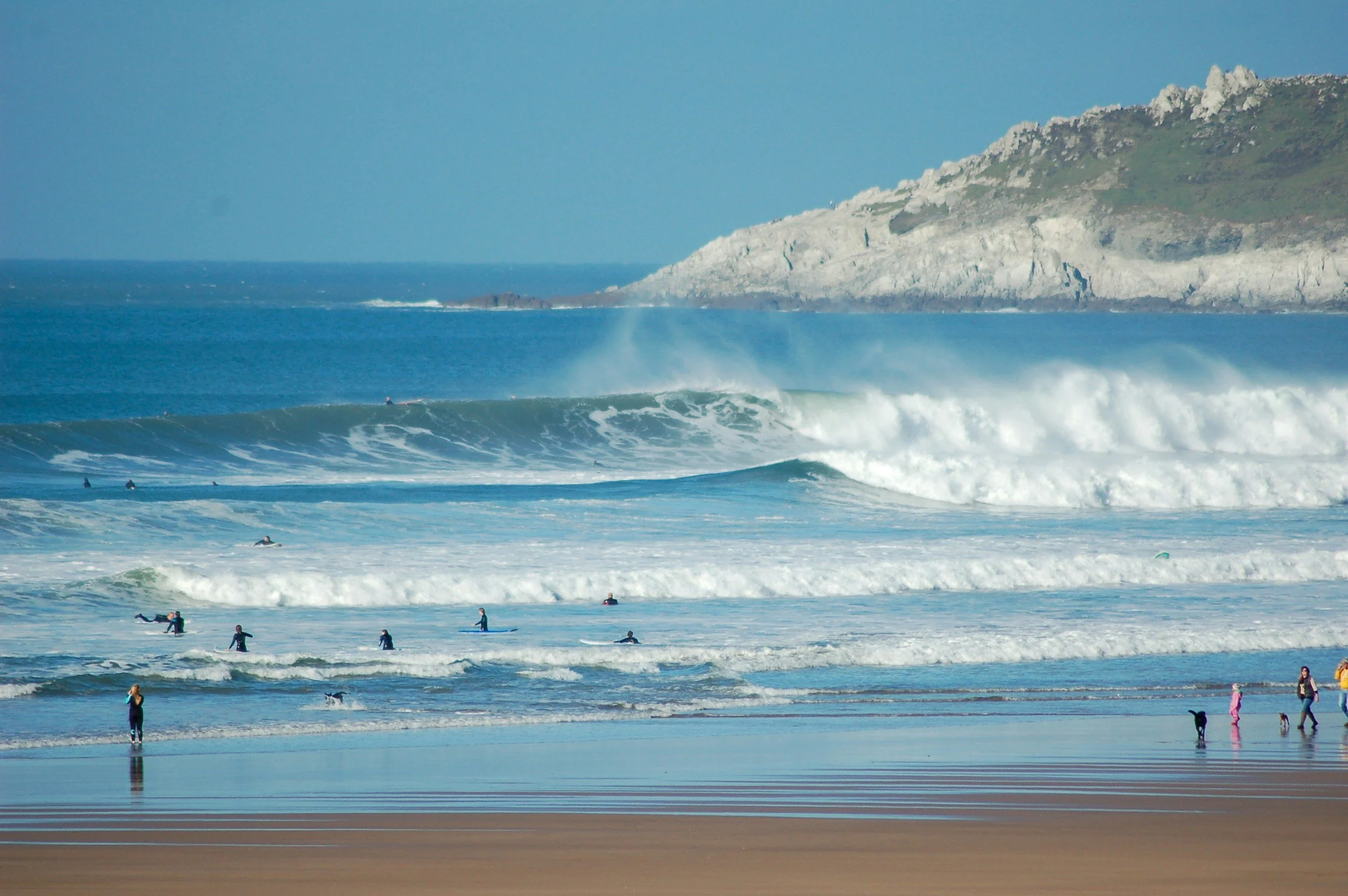 people surfing on a beach in devon.