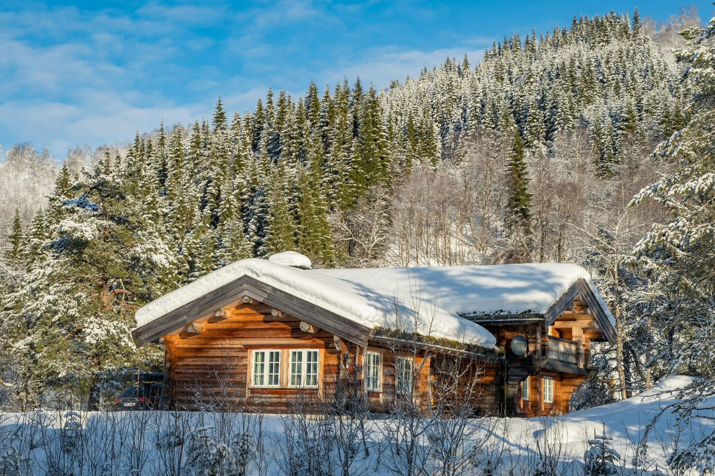 Comfortable Norwegian mountain cabin in winter with cross-country ski trails just outside, showing everyday winter life in the mountains.