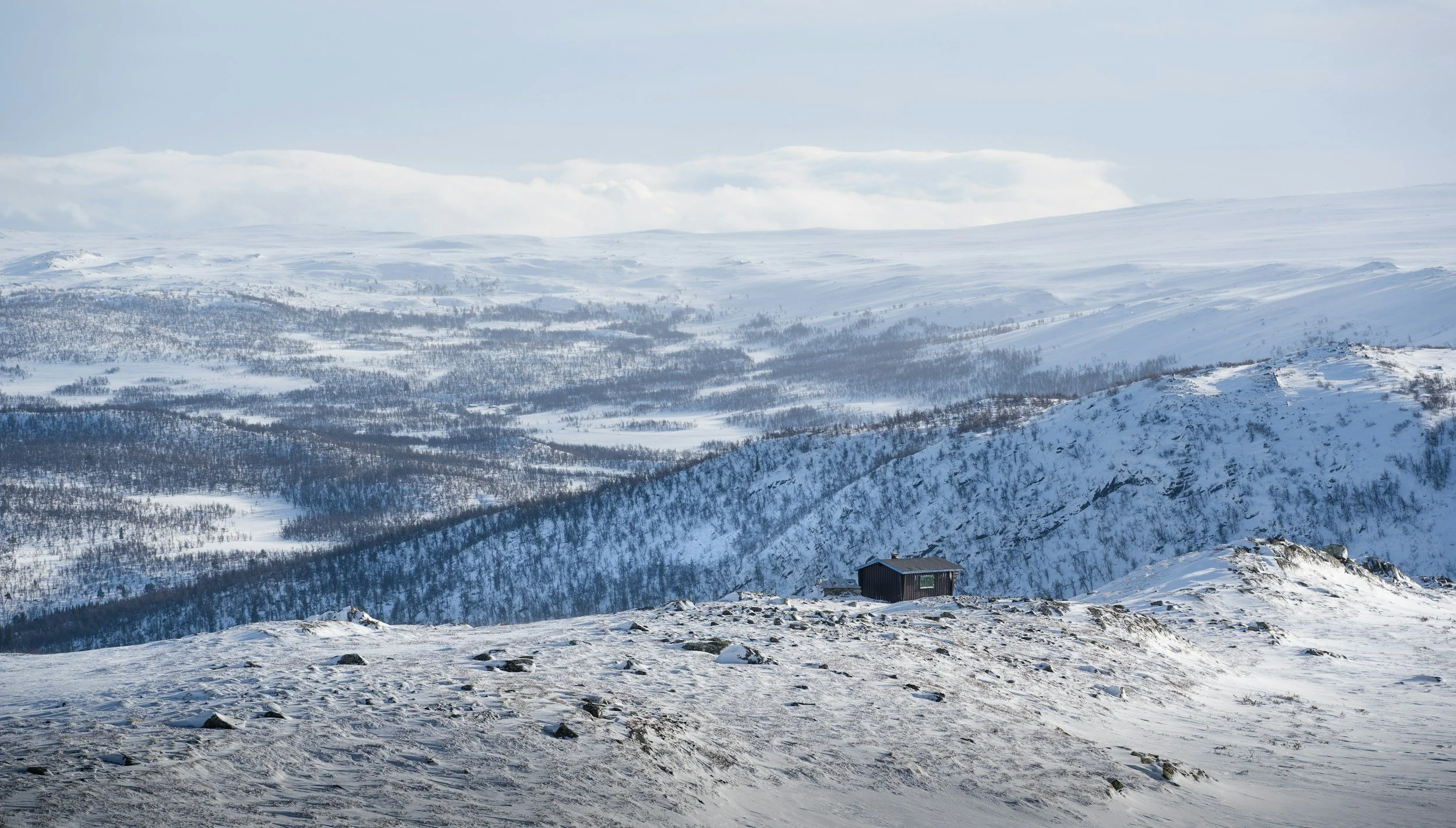 Open winter landscape near Geilo with snow-covered mountain plateau and distant valleys under soft winter light.