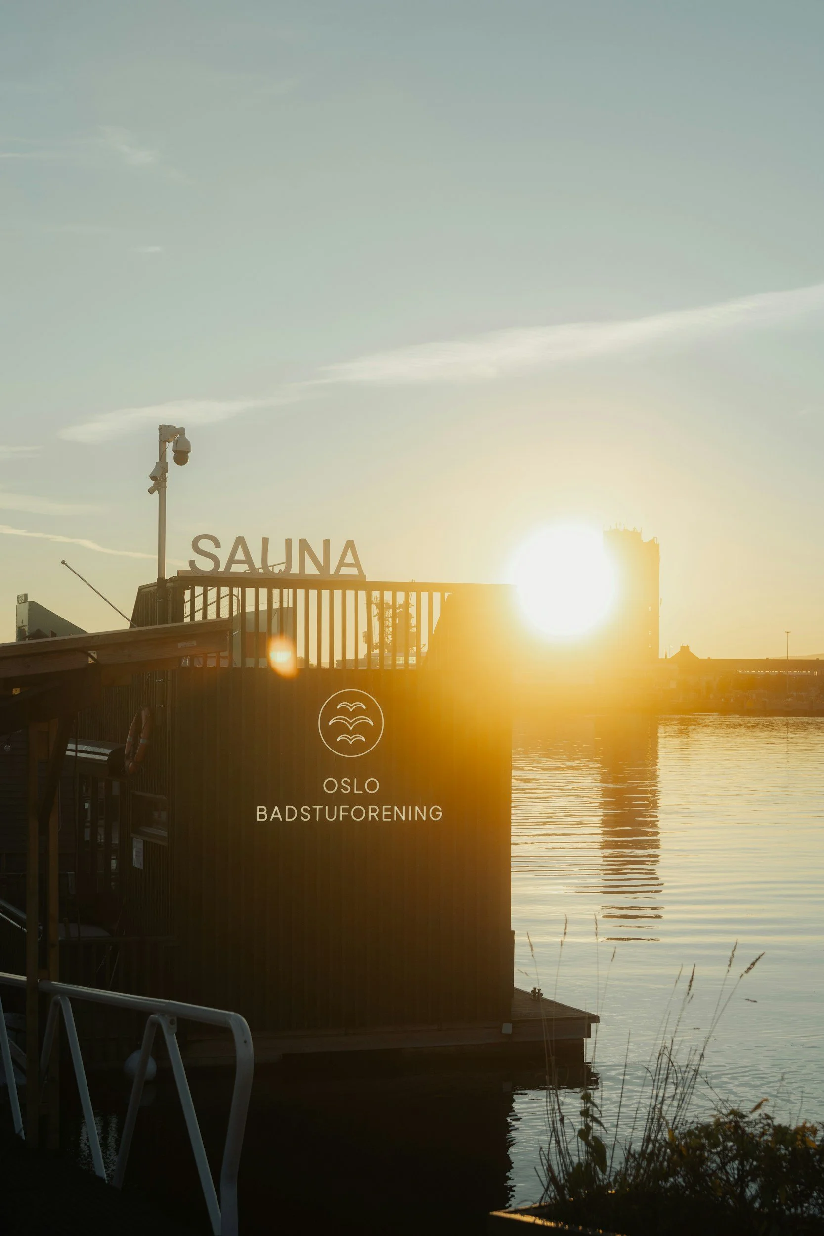 A picture of an outdoor sauna in the oslo fjord at sunrise.