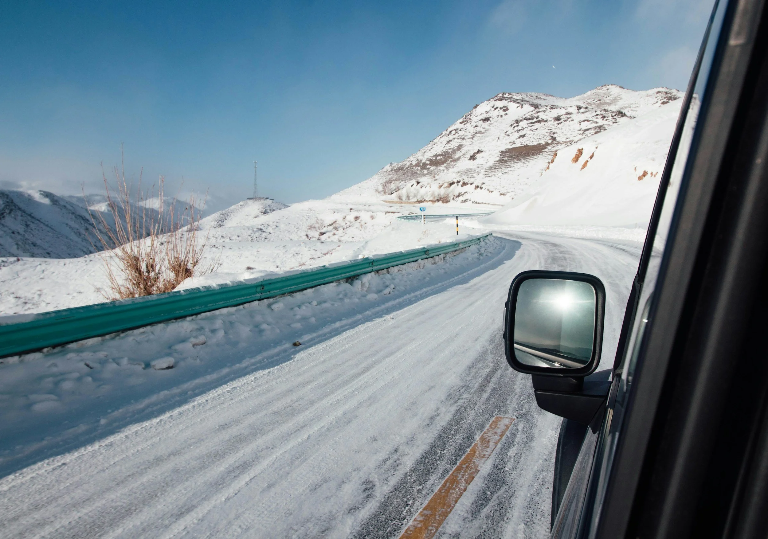 Icy winter road in the Norwegian mountains highlighting the need for proper tyres, speed adjustment and careful driving.