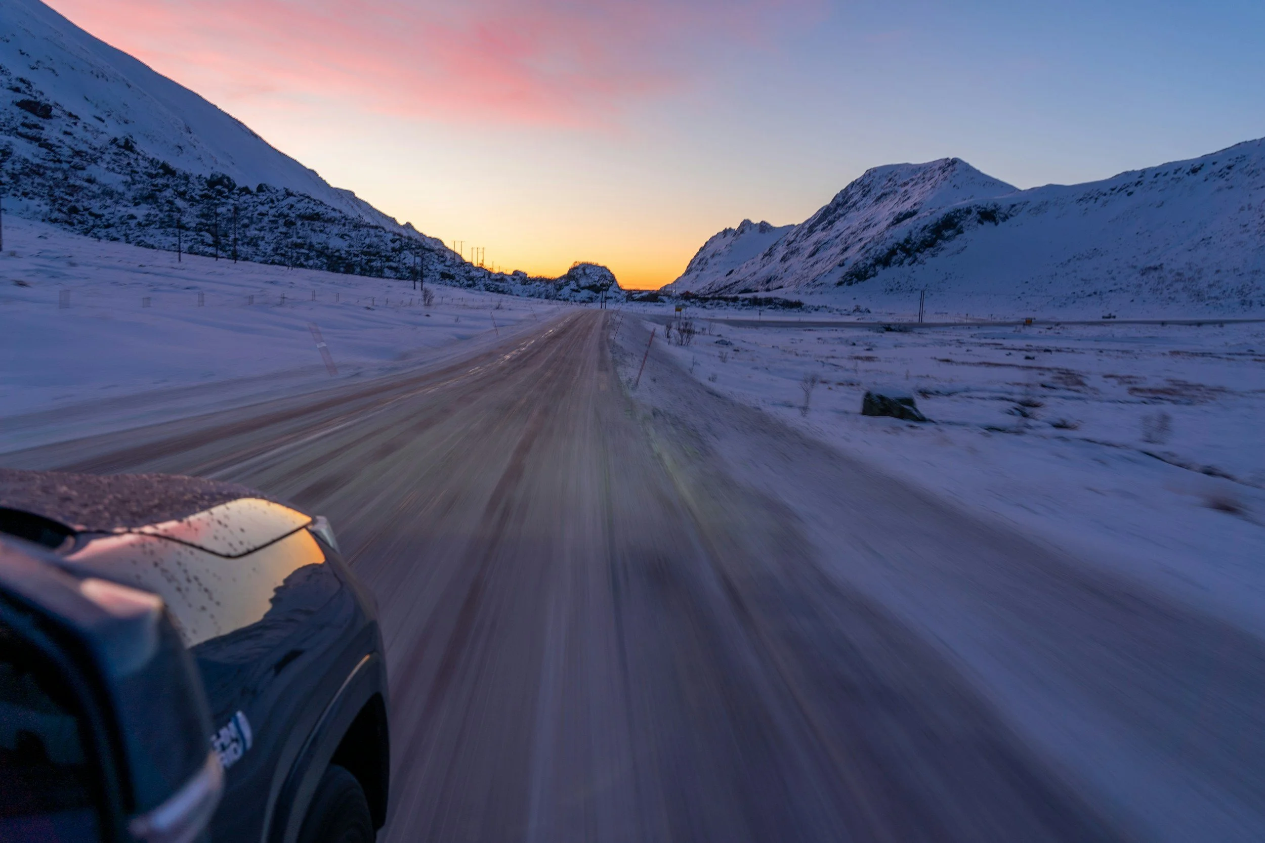 Driving on an icy road in Northern Norway at dusk, illustrating the winter conditions visitors often underestimate.