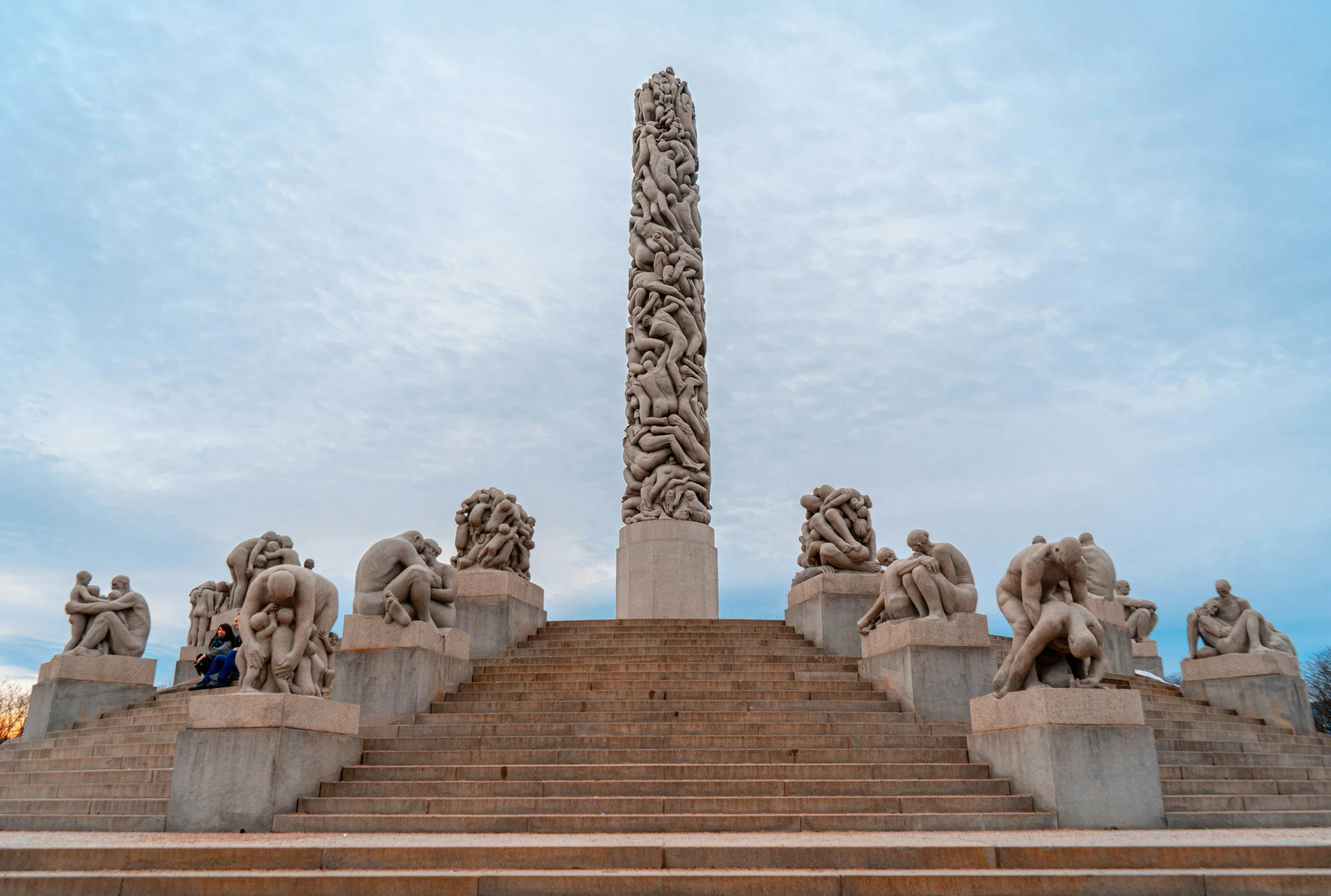 A picture of Monolitten, a constallation of statues at Vigelandsparken in Oslo, naked people are crawling on top of each other.