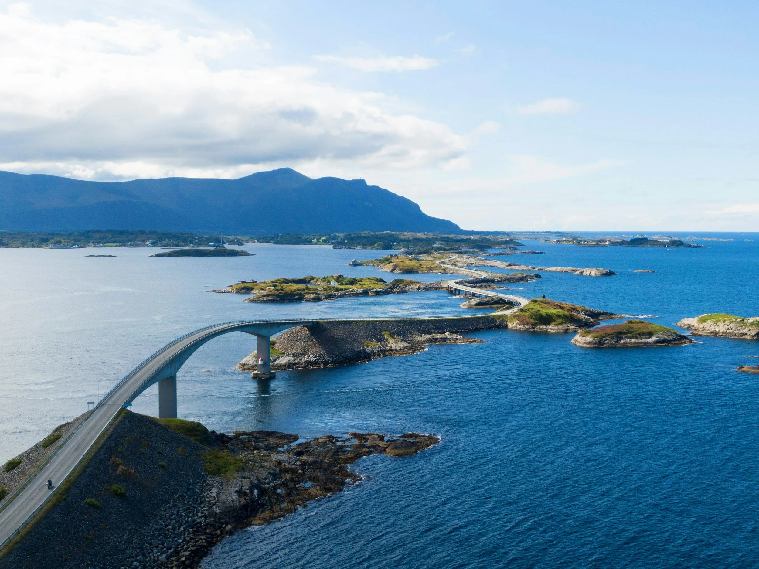 A picture of a scenic road in Norway, crossing water.