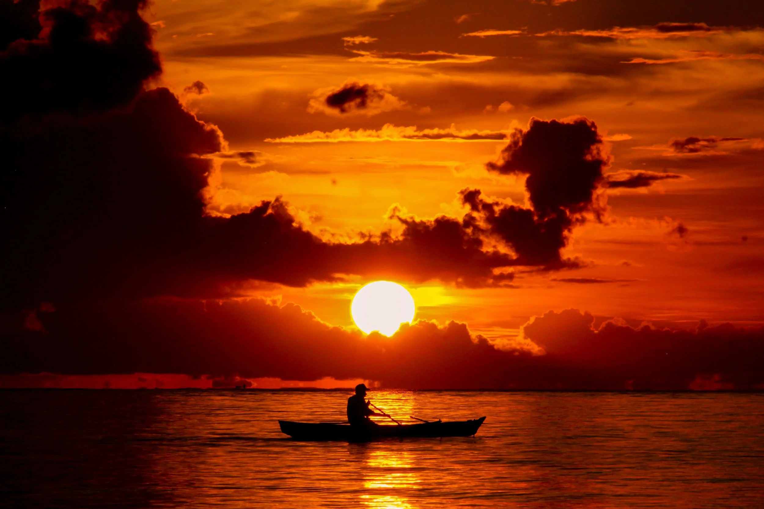 A kayaker in front of the sunset in Senja.
