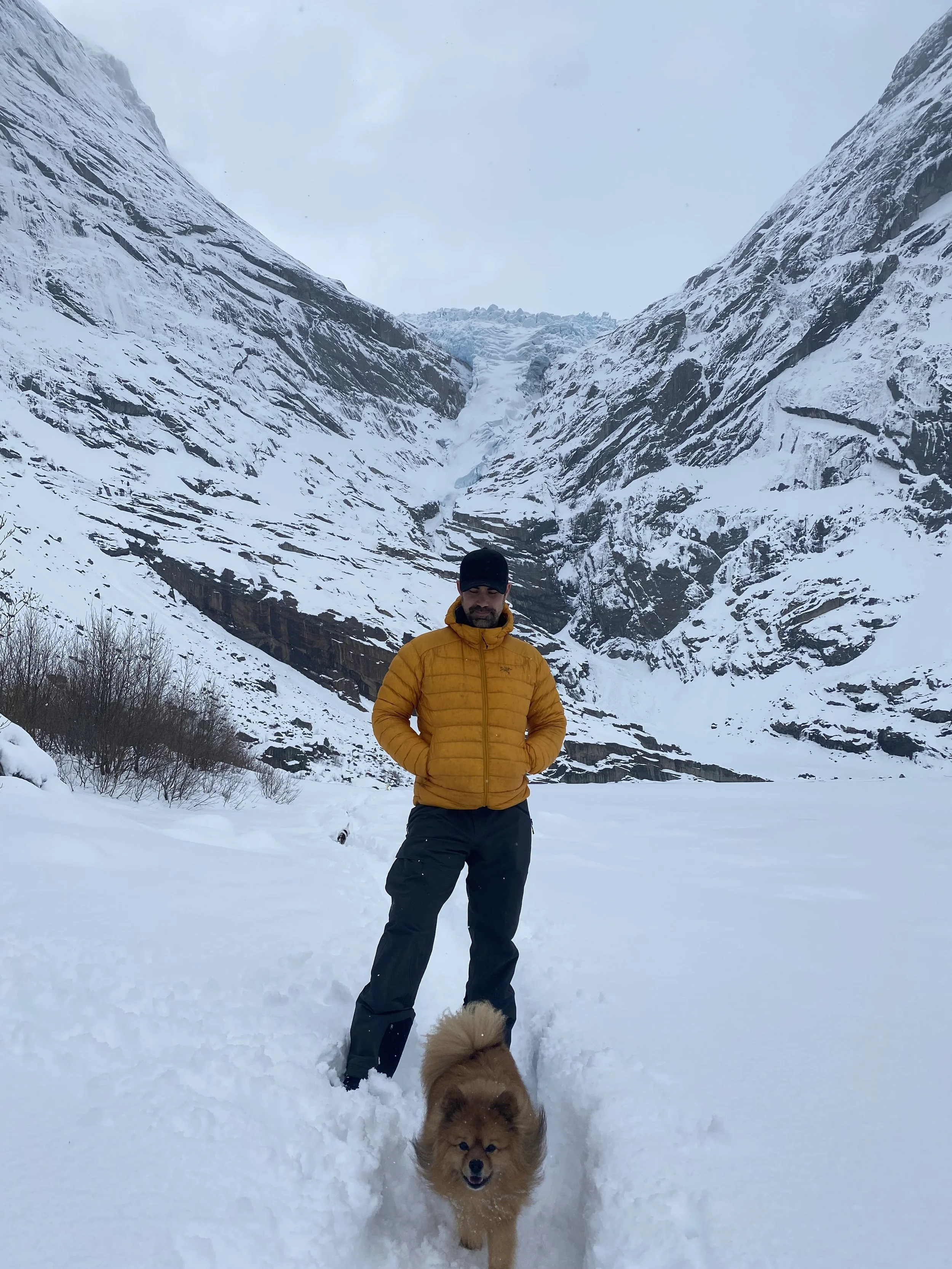 Wearing insulated winter clothing while walking through deep snow in the Norwegian mountains.