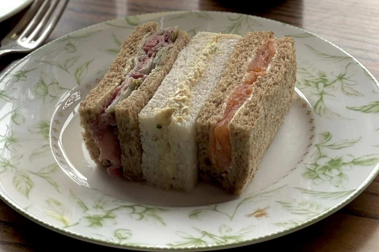 assorted finger sandwiches served on a plate during afternoon tea.