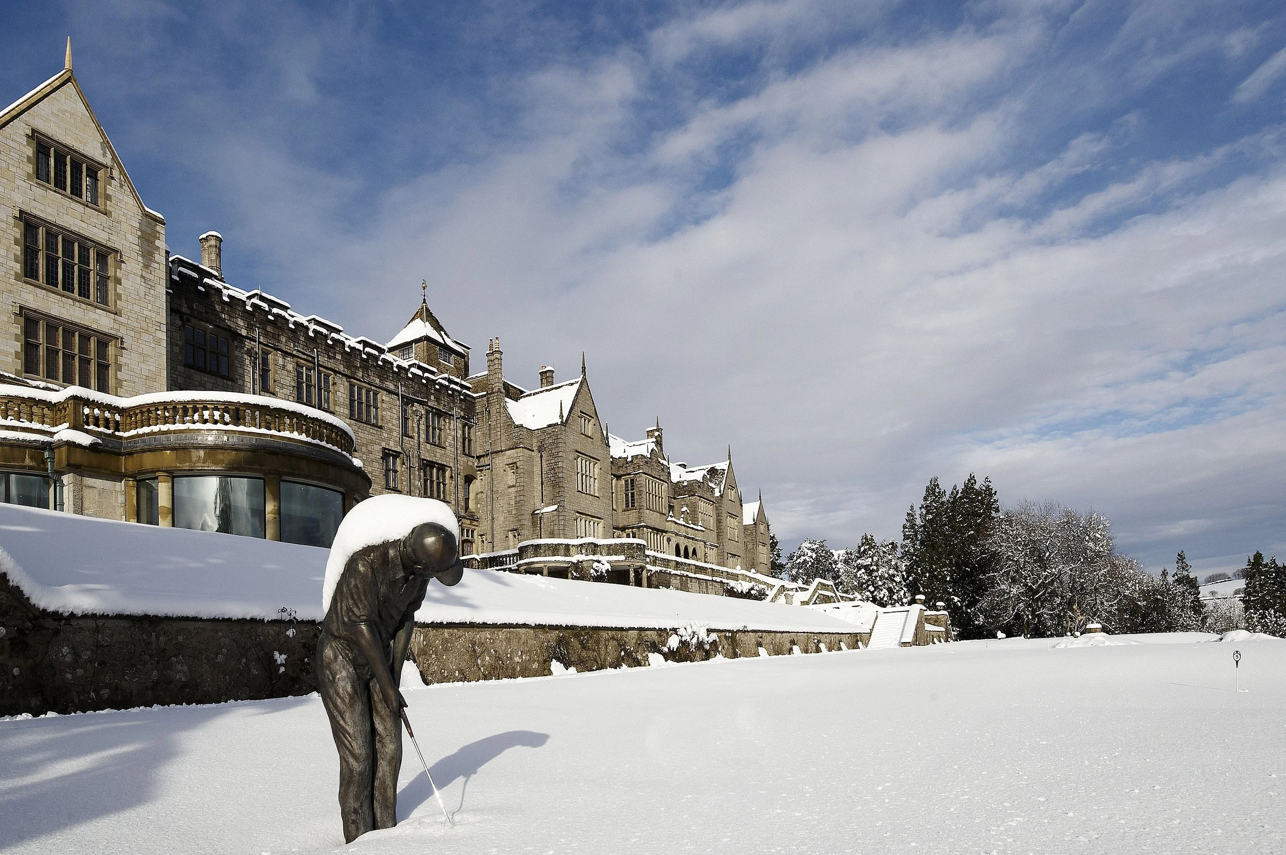 Bovey Castle exterior in winter, with snow-covered grounds and the historic stone building set in Dartmoor National Park.
