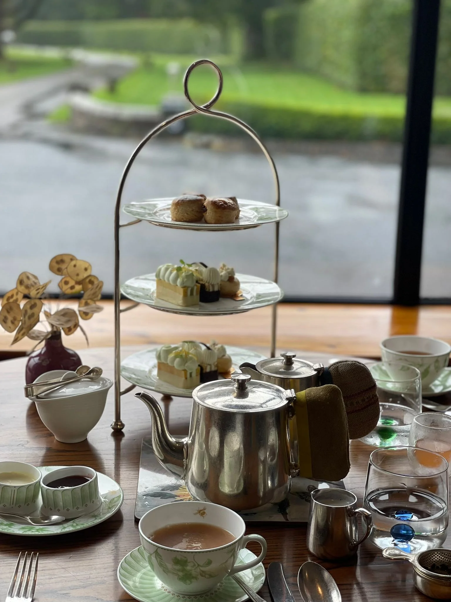 Silver teapot and teacup on a table during a traditional British afternoon tea