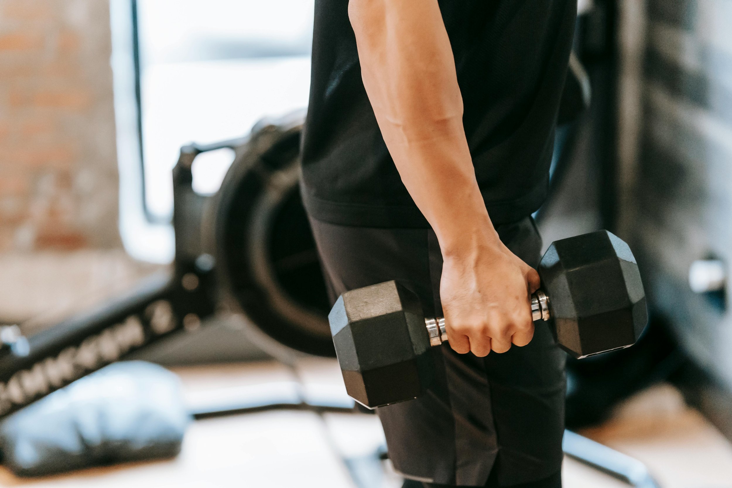 A man lifts hand weights during physical therapy
