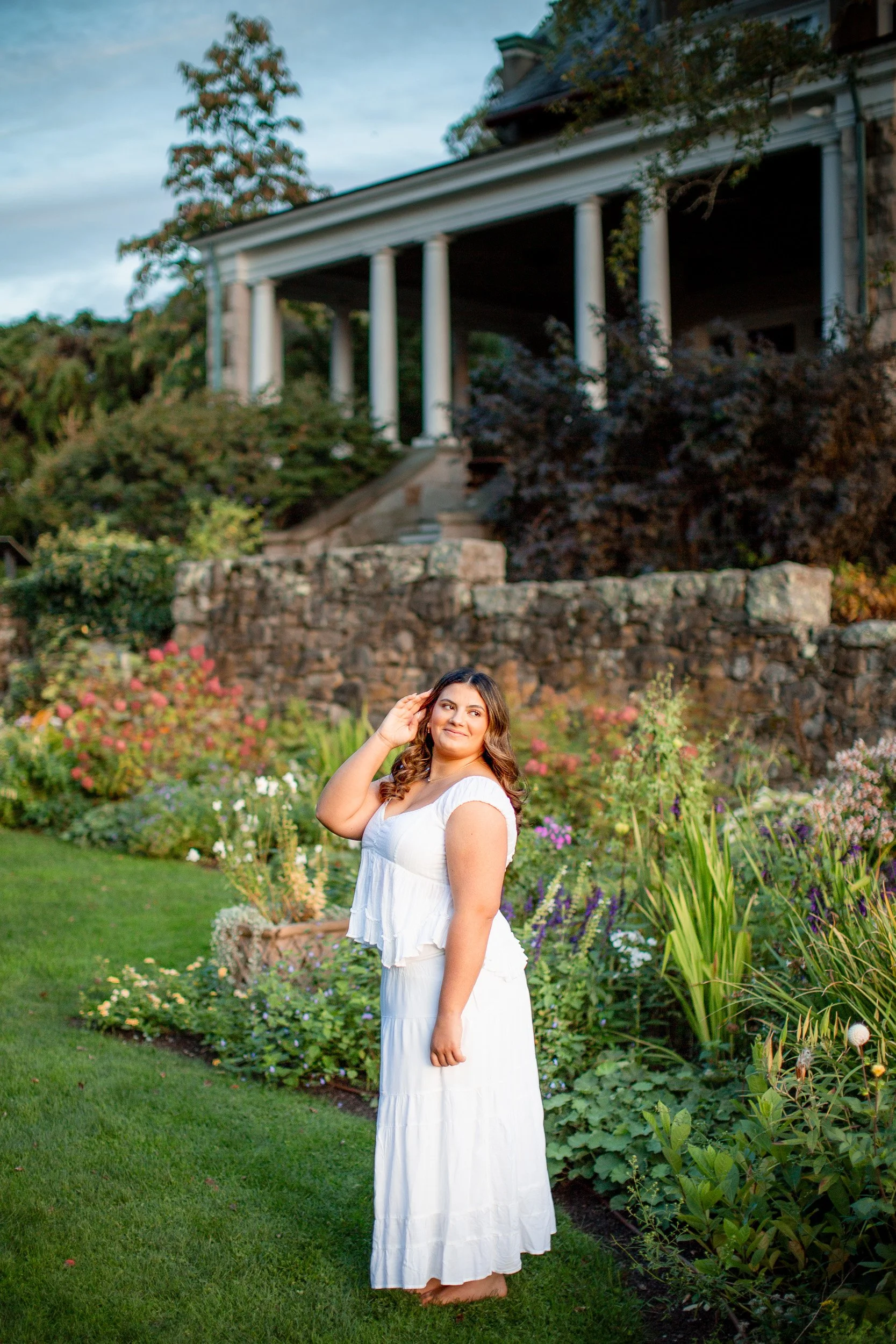 Senior portrait in a white dress outside Blithewold Mansion in Bristol, RI